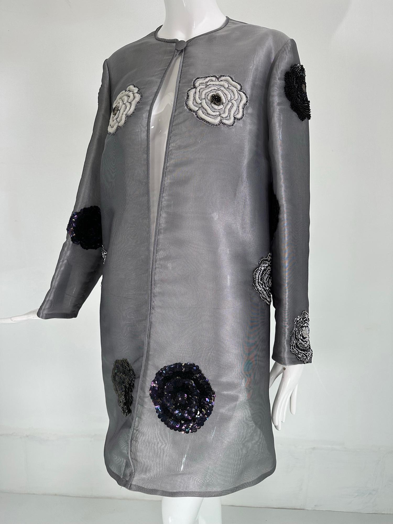 Manteau de soirée en organza de soie grise, brodé de perles, de paillettes et de cercles. Manteau en organza gris transparent avec des cercles rembourrés qui sont recouverts de paillettes, de perles ou de broderies de différentes couleurs et de
