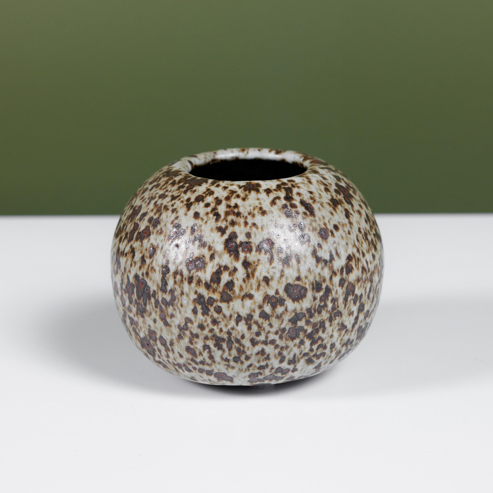 Wheel thrown studio ceramic bud vase with gray glaze. The rounded vessel features a gray and dark brown speckled glaze with circular opening at the center of the vase.

Dimensions
4