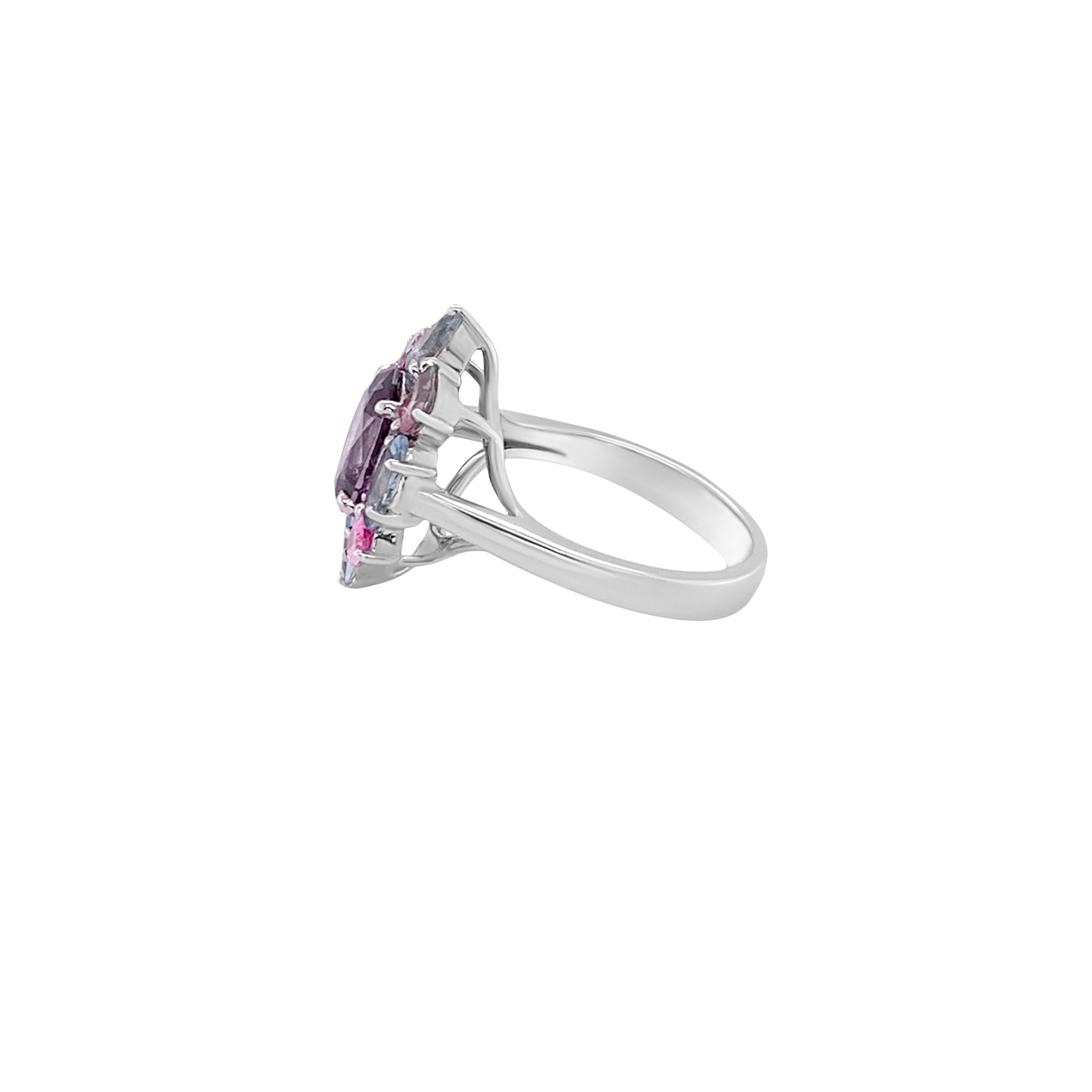 A Tri-Colored cluster ring set in 18 karat white gold with a 2.51 carat Gray Spinel center stone surrounded by 0.77 carat pear shaped Pink Spinel along with 0.83 carat pear and marquise shaped Aquamarines.  This ring's design is a delightful twist