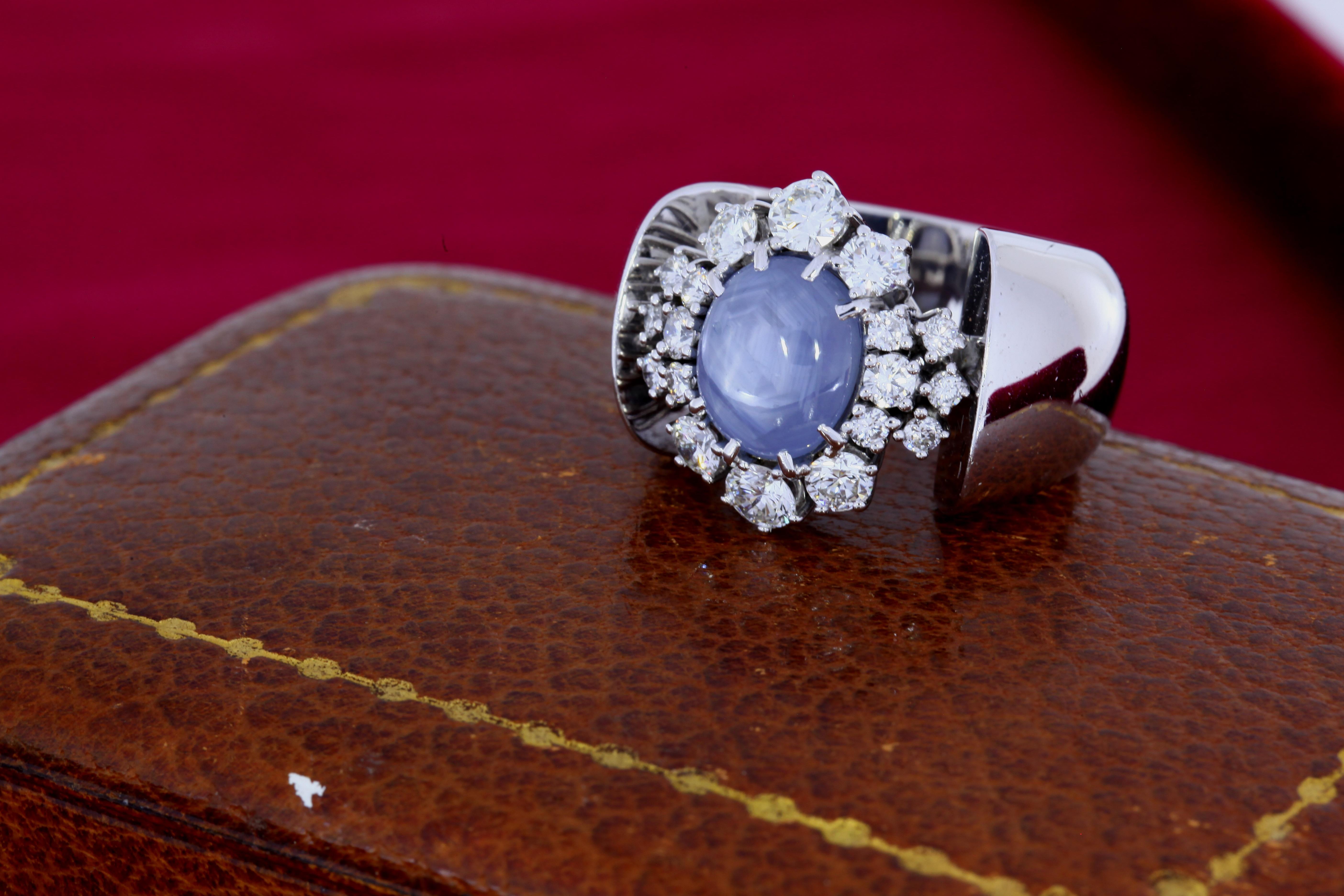 Gray Star Sapphire weighing approximately 7 carats accompanies by 1.5 carats of diamonds in the surrounding cluster set in a platinum ring. 