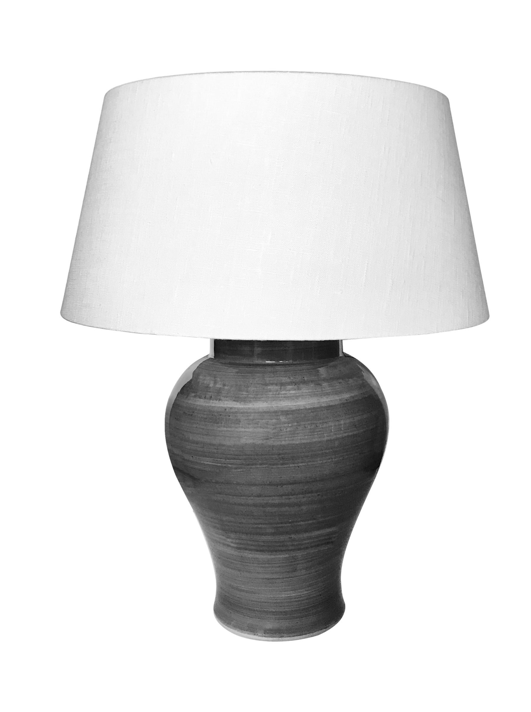 Pair of horizontally striated design Classic shape gray glazed lamps.
New Belgian linen shades.
Measures: Overall height 22.5
