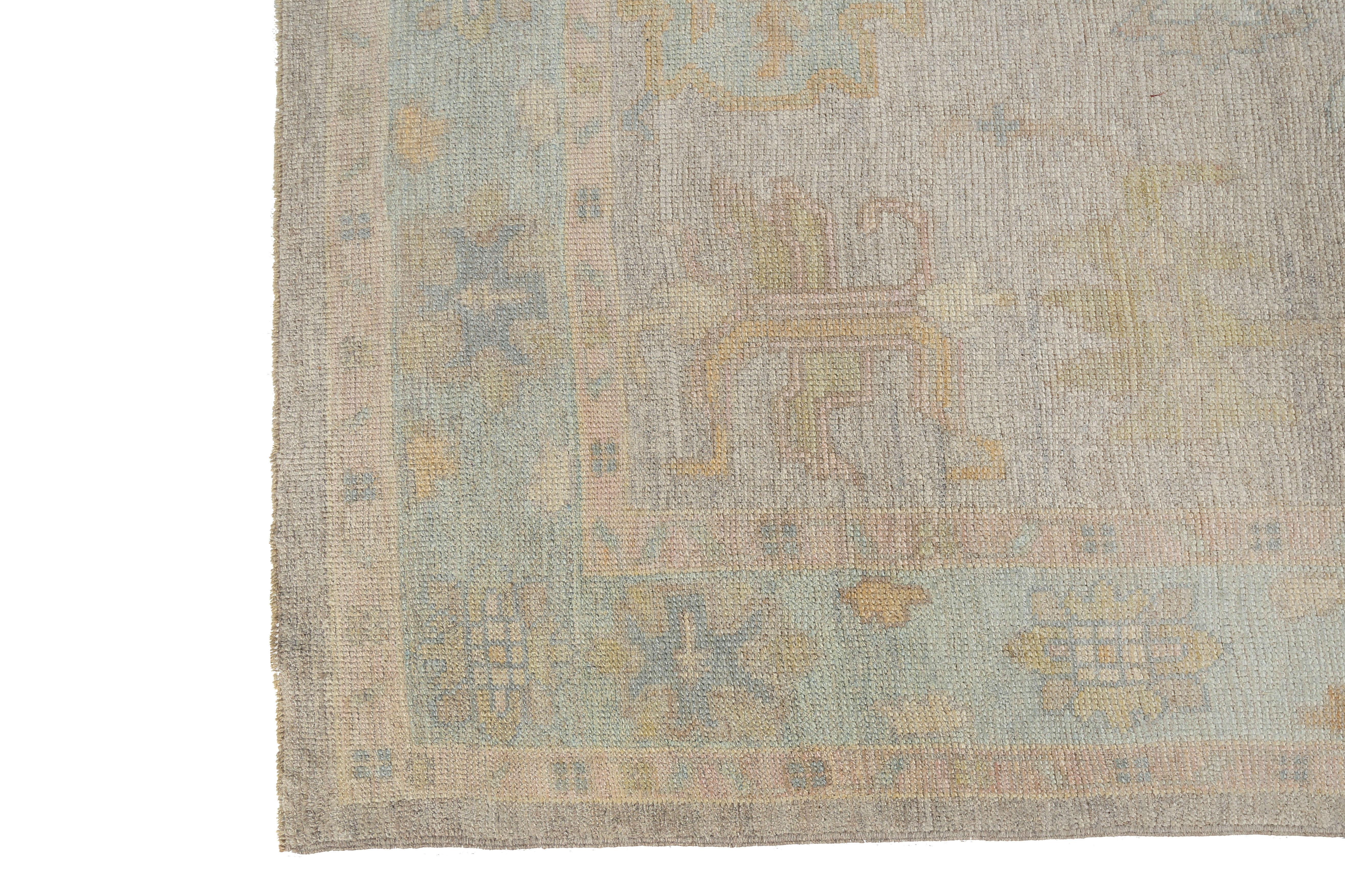 Introducing our exquisite handmade Turkish Oushak rug with a stunning grey background and a beautiful design featuring muted pastel colors of blue, pink, and green. The intricate patterns and soft colors of this rug make it the perfect addition to