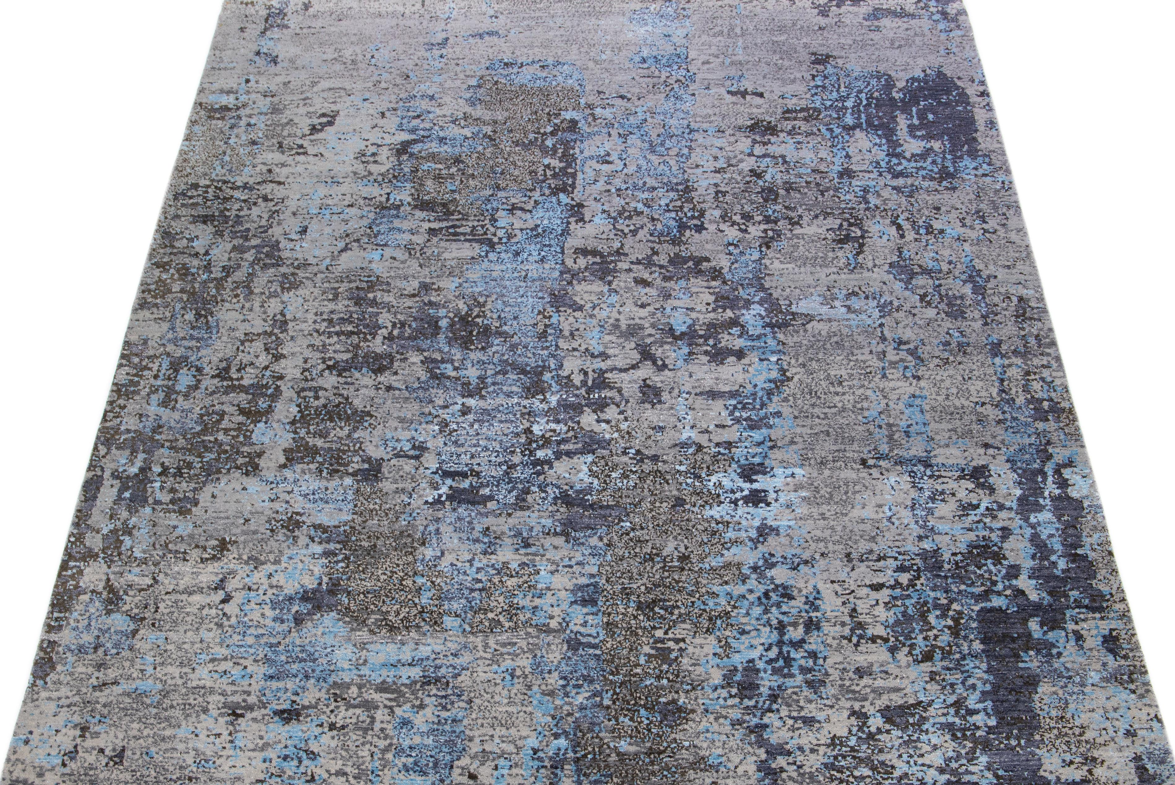 This Indian wool and silk blend rug features a gray field with an abstract pattern detailing blue colors. Its composed materials provide robustness and longevity, while its ornamental design infuses any room with sophistication.

This rug measures