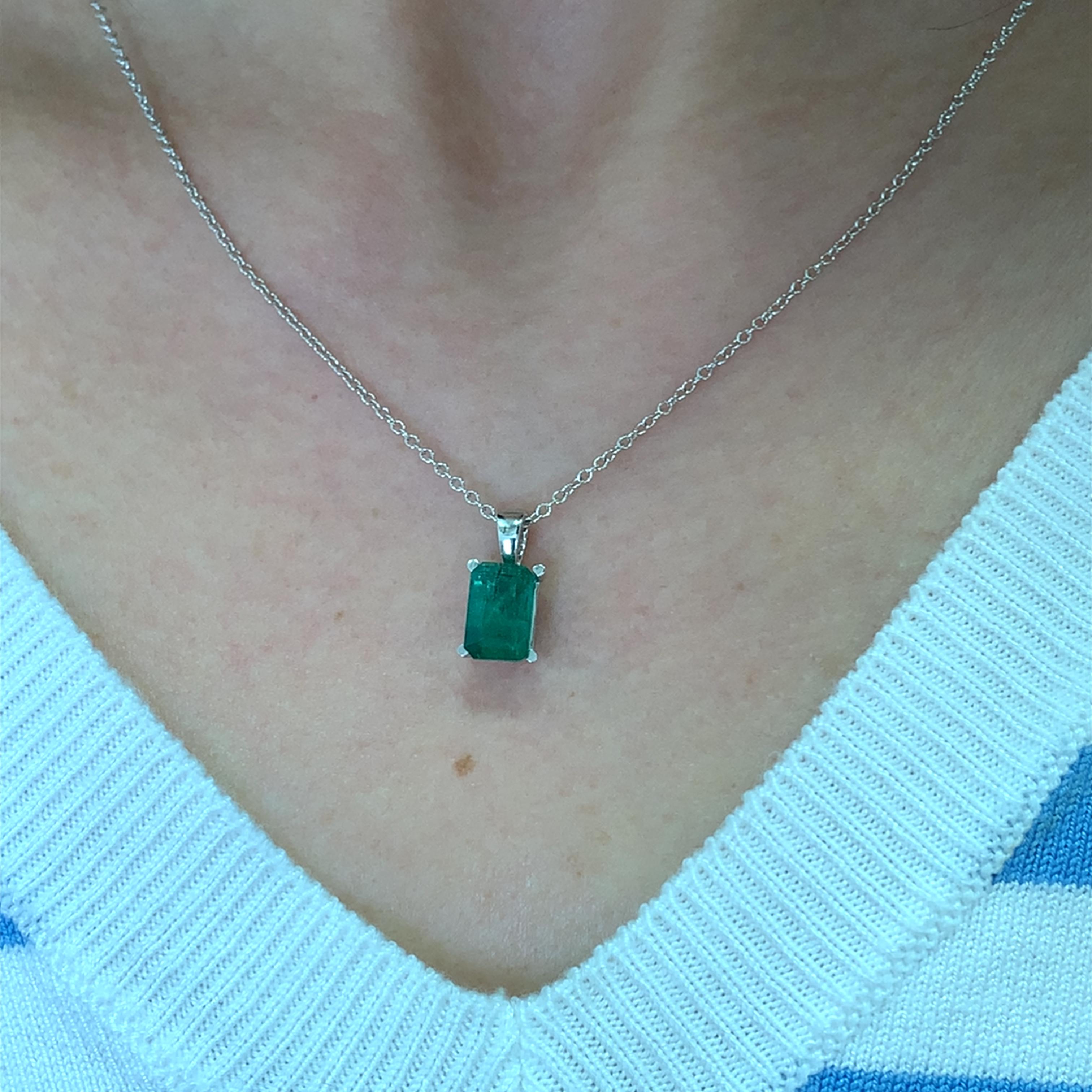 Questa splendida collana con ciondolo a forma di smeraldo da 2,10 carati presenta una gemma verde vibrante di circa 9/7 mm con alcune inclusioni naturali, elegantemente incastonata in un'elegante catena in oro bianco 18 carati da 16 pollici.