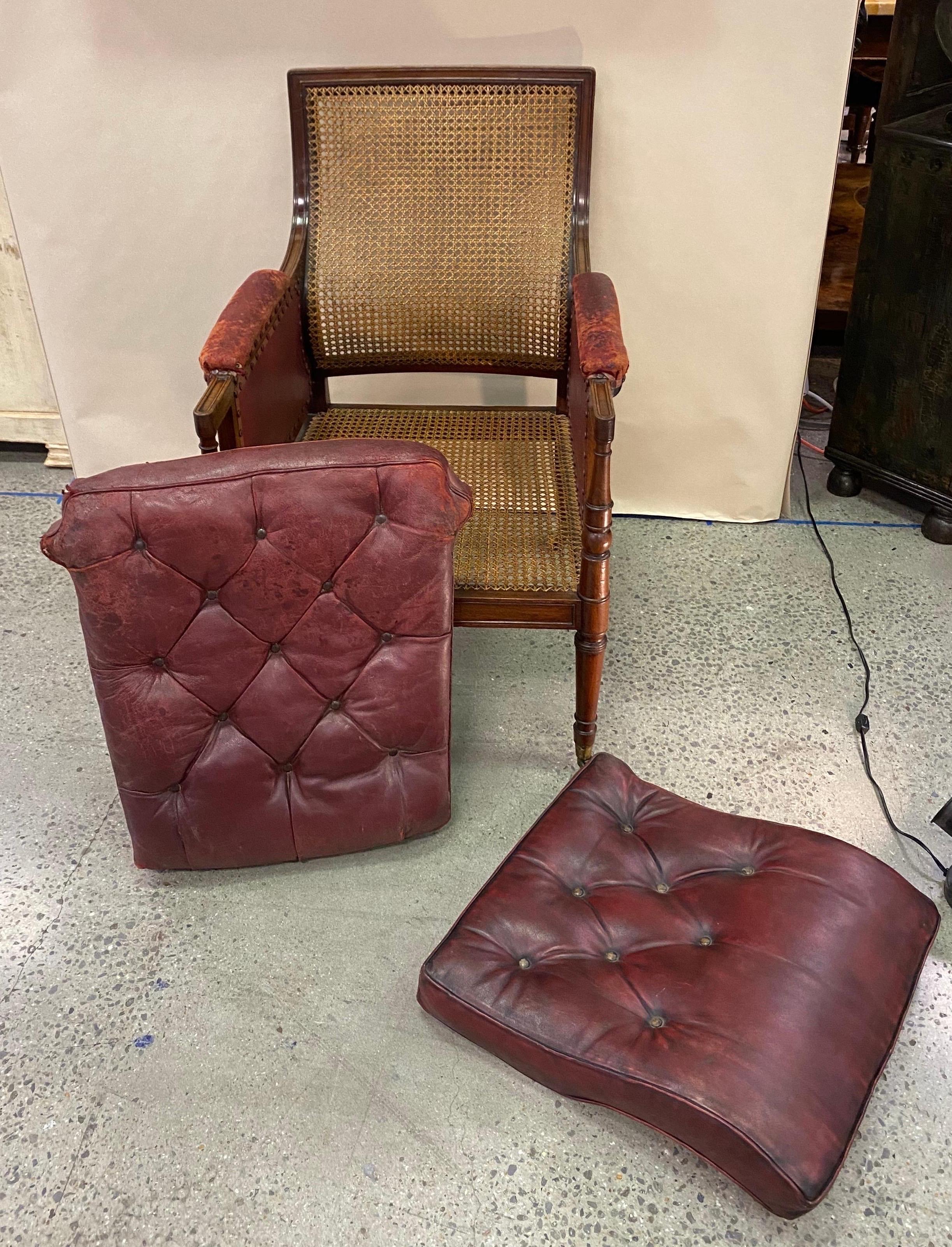 Great 19th century English mahogany and cane library chair with leather cushions. Wonderful color and patina. Nice turned legs and curved back. Cane is in perfect shape. The cushions do have a few little tears in corners and the leather armrests are