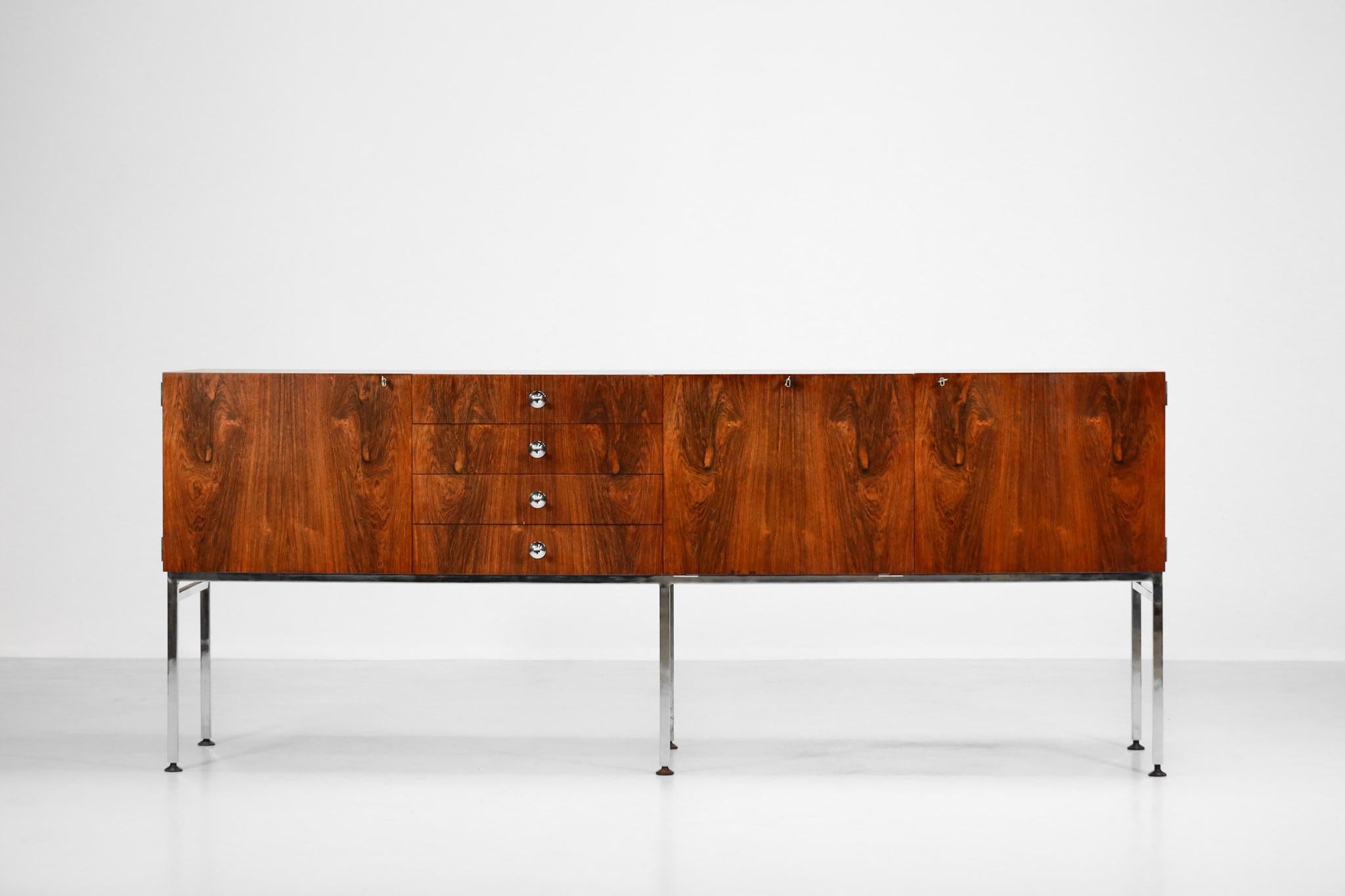 Great sideboard designed in 1958 by the French designer Alain Richard for Meuble TV. 
Excellent workmanship in rosewood resting on a chromed steel frame. 
Composed of a first left hinged door, a central column with 4 drawers, then a double hinged