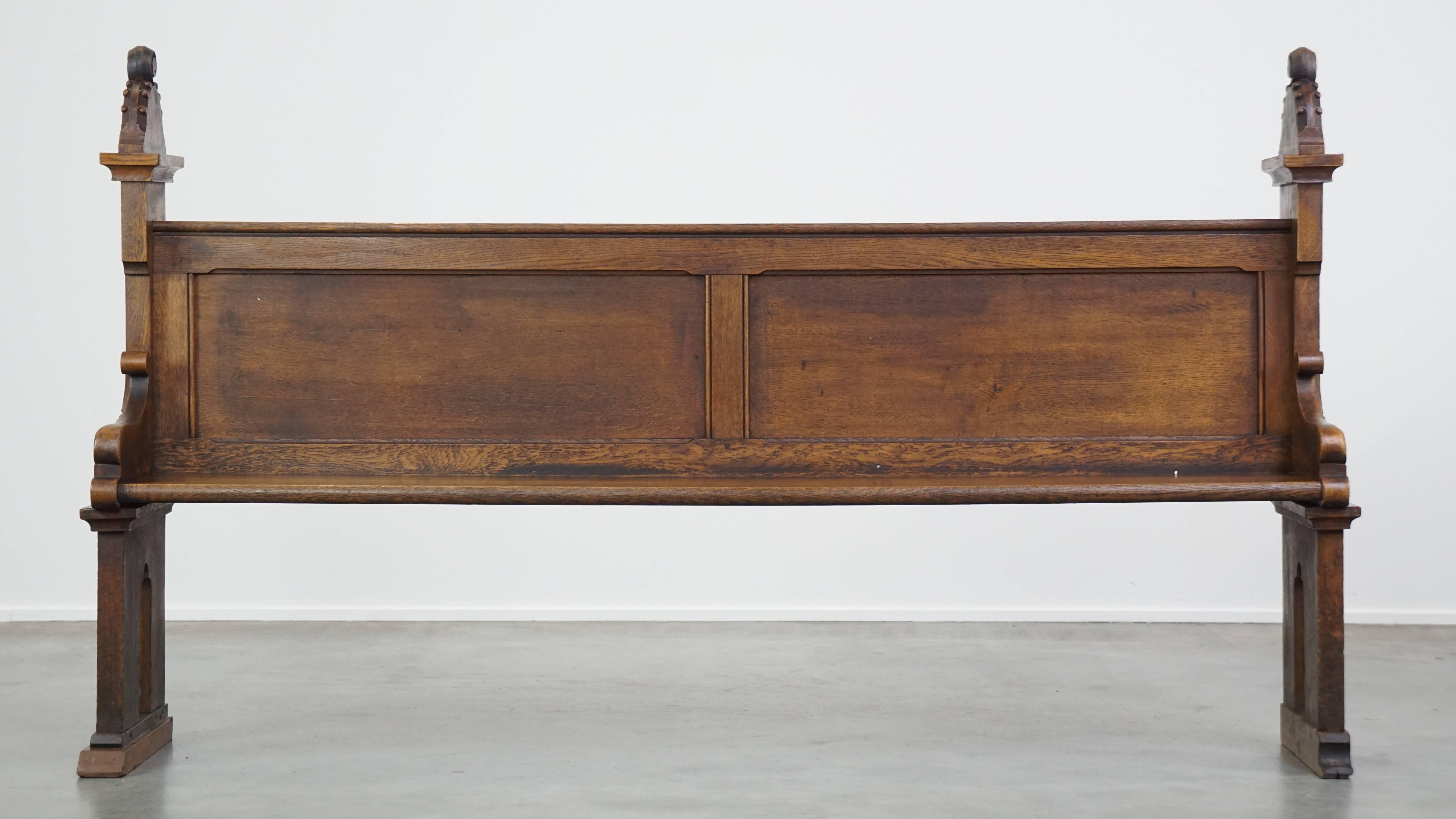 This wonderful antique freestanding oak church pew in gothic style from the late 19th century is a fantastic addition for enthusiasts. It is beautifully carved and has had one new foot replaced. Due to its considerable age, it has developed normal