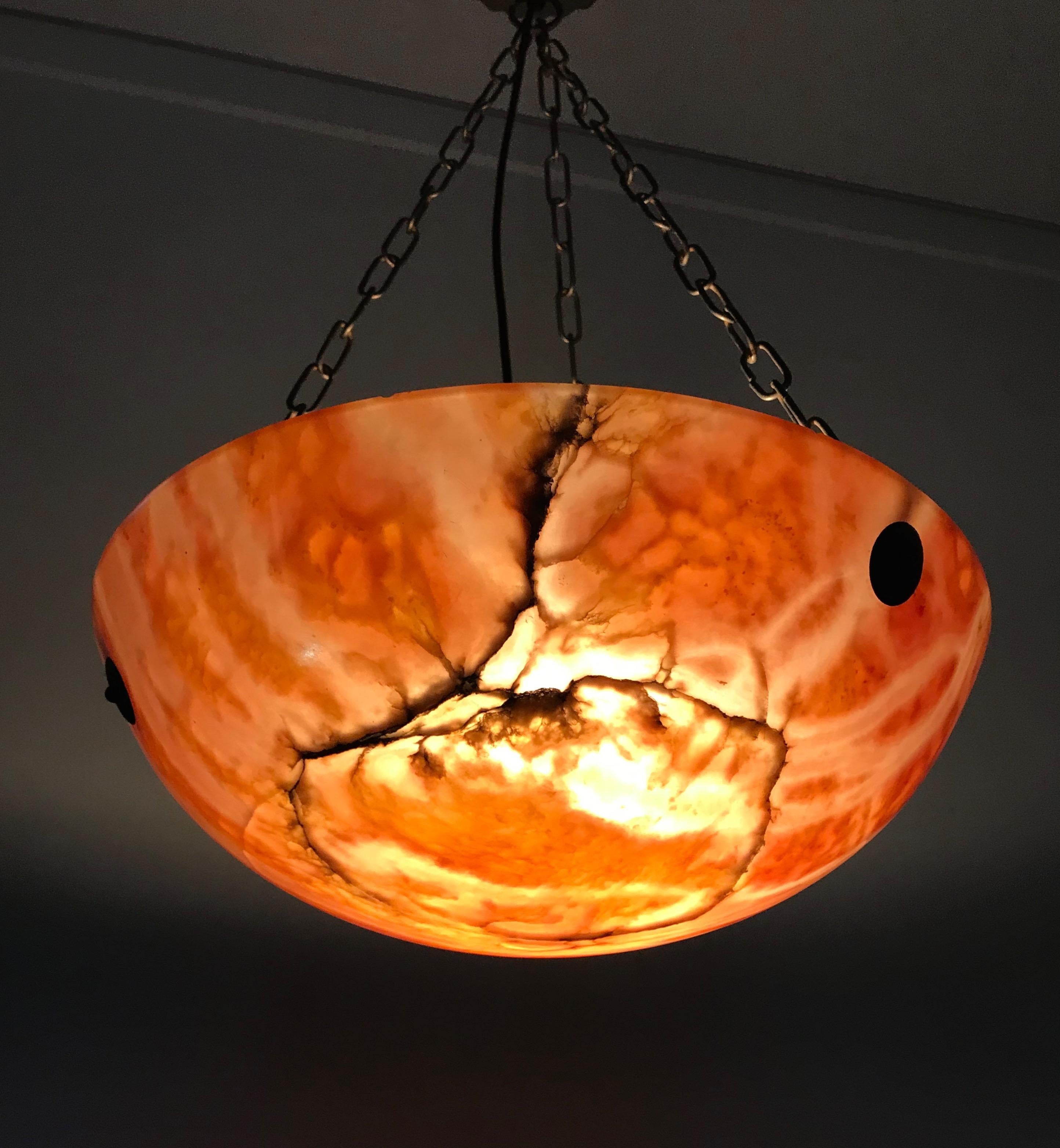 Good condition, Italian Antique. 1920s pendant light.

If you like the Art Deco style in general and Art Deco chandeliers in particular, then this alabaster shade and iron chains light fixture could be perfect for you. Both with the light switched
