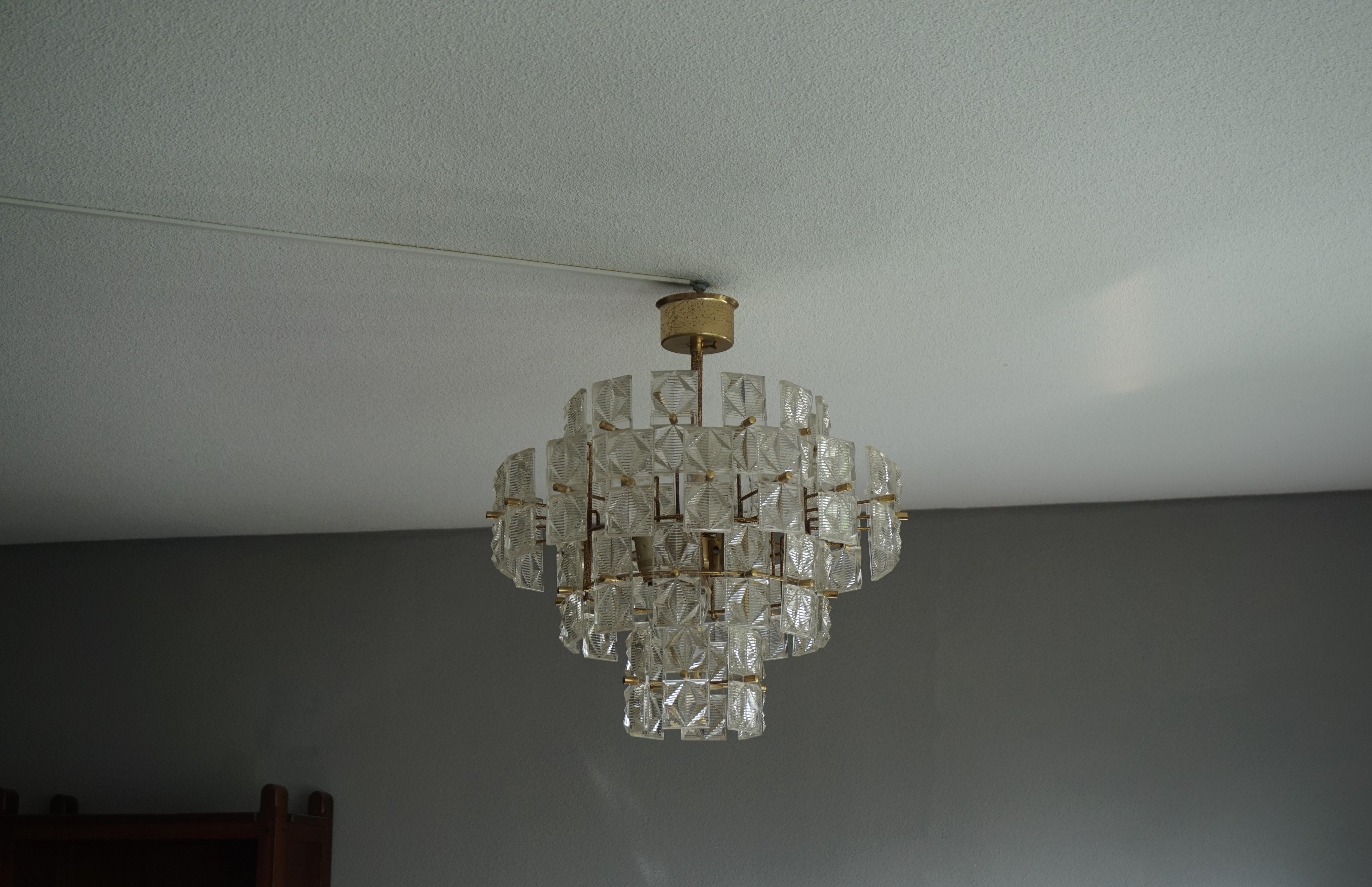 Stylish and wonderful light creating midcentury chandelier.

It is very hard to explain why certain light fixtures appeal more to a larger group of people than others. To us, there is something about the shape, the colors and the mix of materials