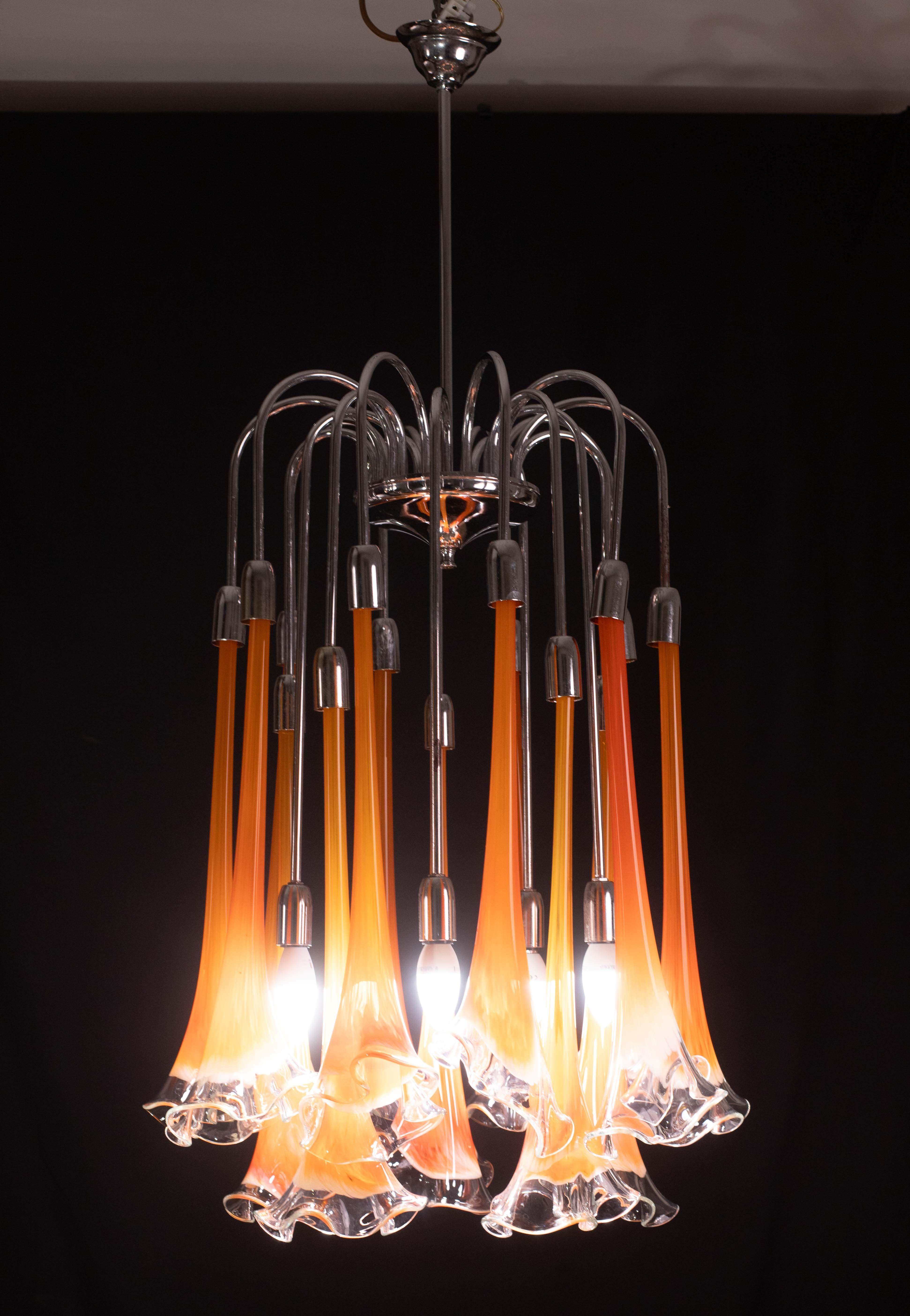 Extraordinary and rare orange-colored Murano glass Calle chandelier attributable to Venini.
Design period: 1970.

The frame of the chandelier is chrome-plated steel, some signs of time.

The 15 calle are in perfect vintage condition.

Mounts 5