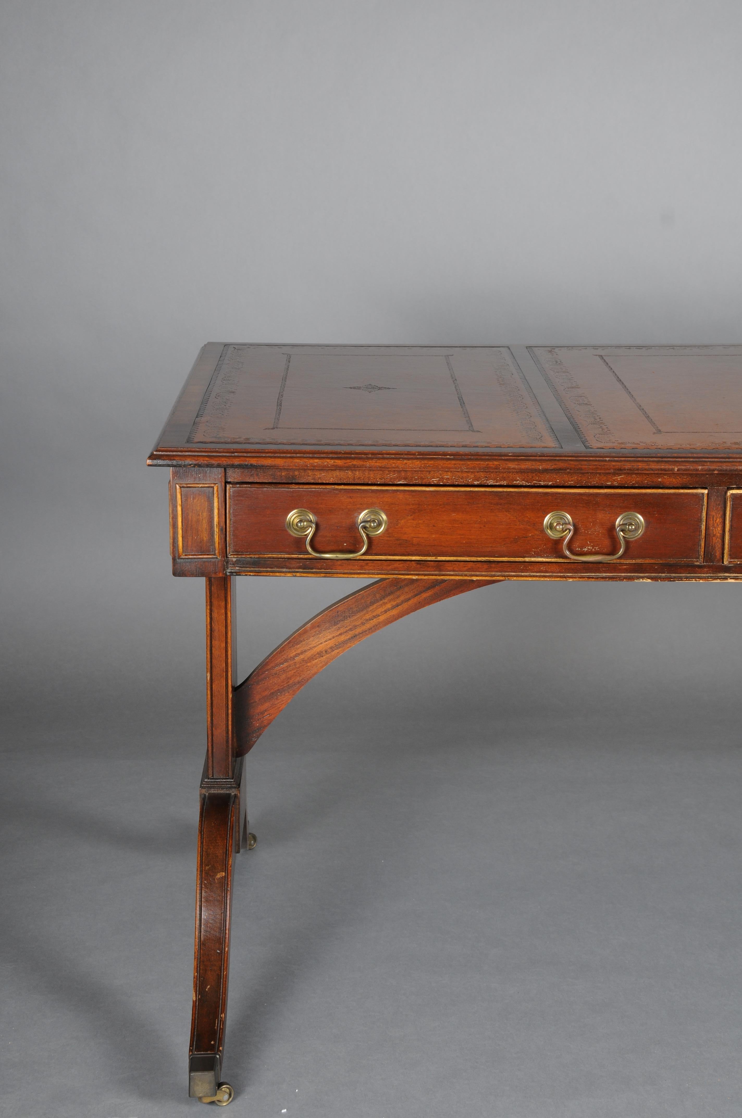Great English partner desk, desk 1870, mahogany

Solid mahogany, partially veneered. Three-drawer frame profiled on both sides, slightly protruding table top. Writing surface decorated with unusual gold embossing. Decorative brass fittings. Curved