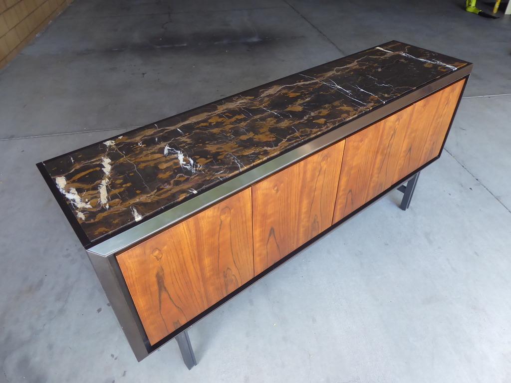 The Great Jones Server was designed by noted interior designer William Sofield for Baker Furniture. Both stylish and functional, the server has a black lacquered body with American walnut doors and a Michelangelo marble top, all raised on an