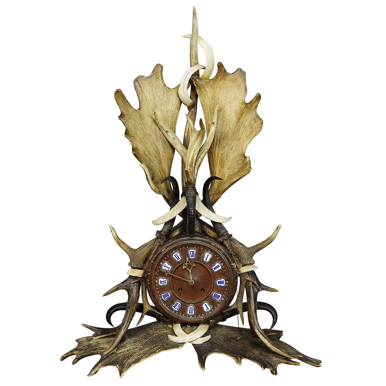 Great Lodge Style Antler Mantel Uhr 1900

Eine seltene antike Kaminsimsuhr im Lodge-Stil. Eichenholzkoffer, reich verziert mit Geweihen von Hirsch und Damhirsch, Bergziegengeweihen und Wildschweinhauern. Das 8-Tage-Uhrwerk ist funktionstüchtig und