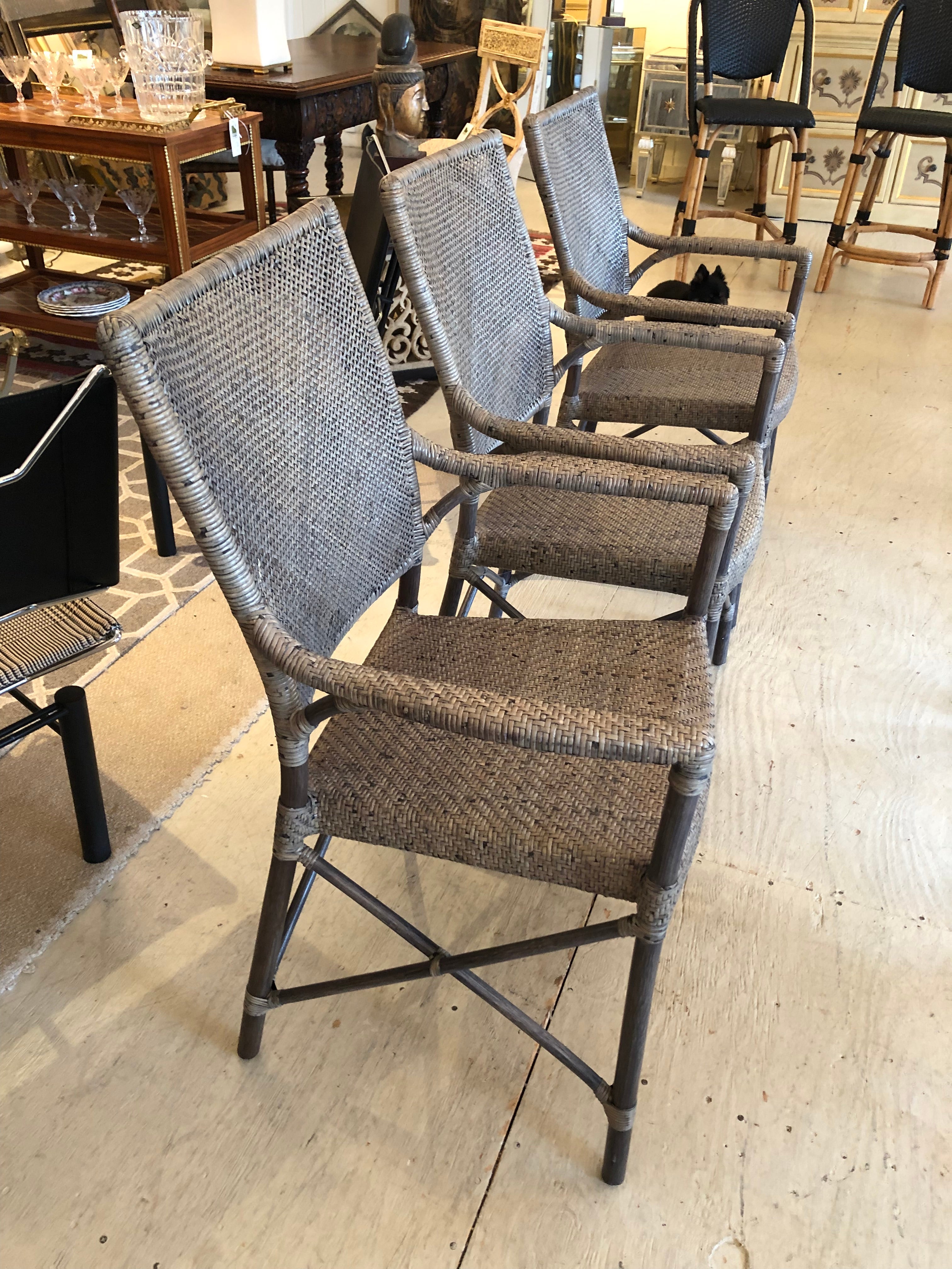 Classic light weight woven rattan armchairs having wood legs and stretcher to match in a handsome shade of taupe.
Set of 3

Measures: arm height 25.
 