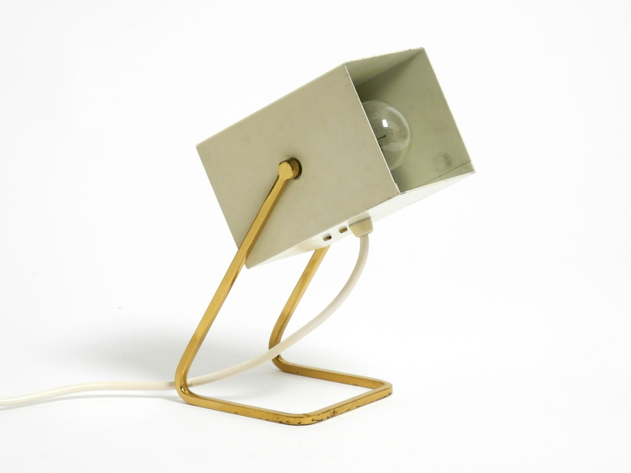 Great Mid Century Modern metal brass table lamp.
Manufacturer: Kaiser Leuchten. Made in Germany.
Beige on the outside and white on the inside.
Very rare with a square shade. Continuously adjustable.
Very high-quality metal construction. Brass