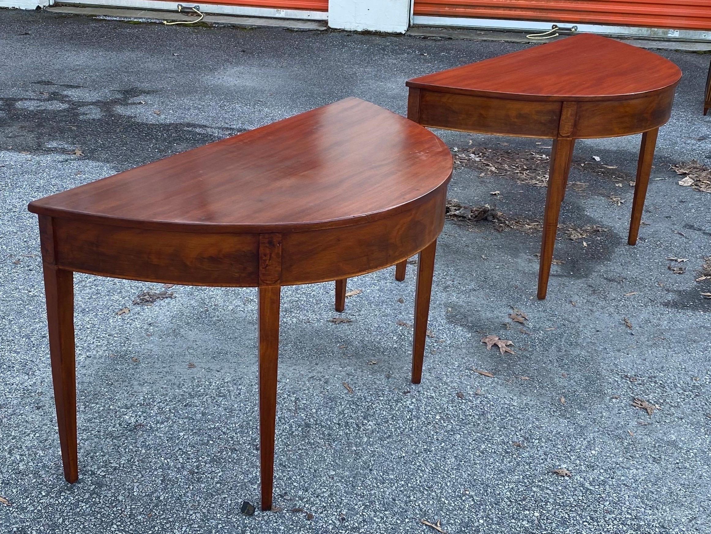 Great pair of 19th century mahogany demilune consoles from an American federal period table. Can be placed together as a dining table.
