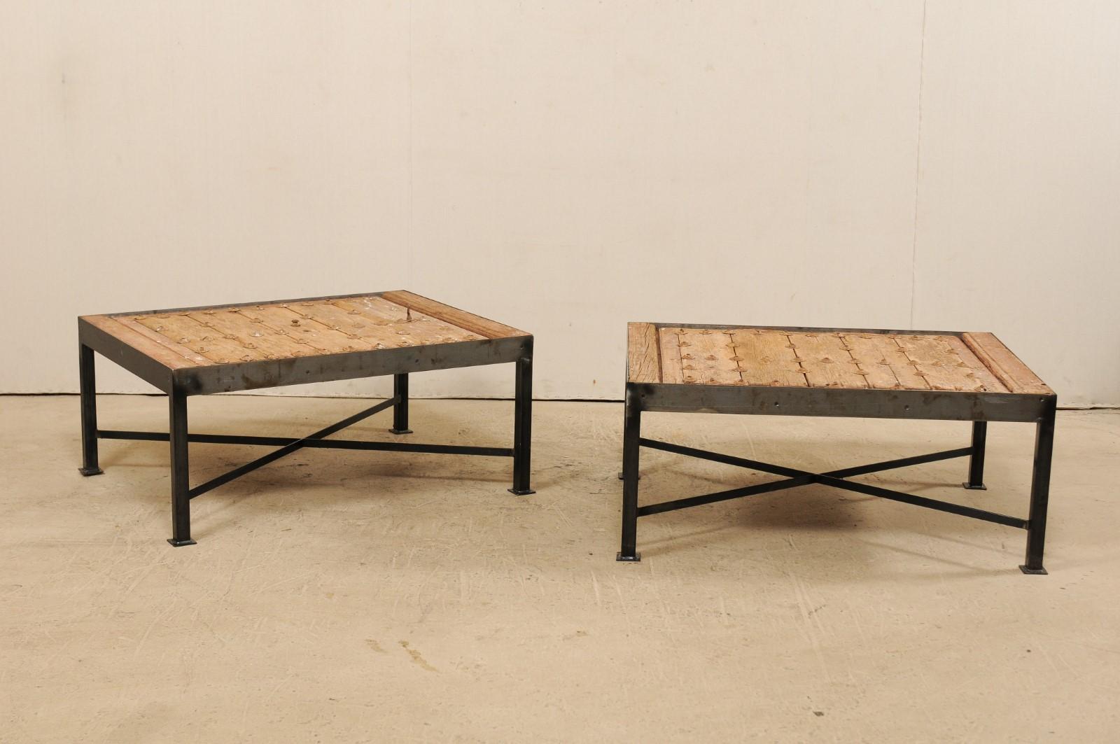 This is a pair of custom coffee tables each made from an 18th century Spanish door. These unique coffee tables have been fashioned from 18th century Spanish doors and featuring wood plank tops with beautifully weathered patinas. Each top is adorned