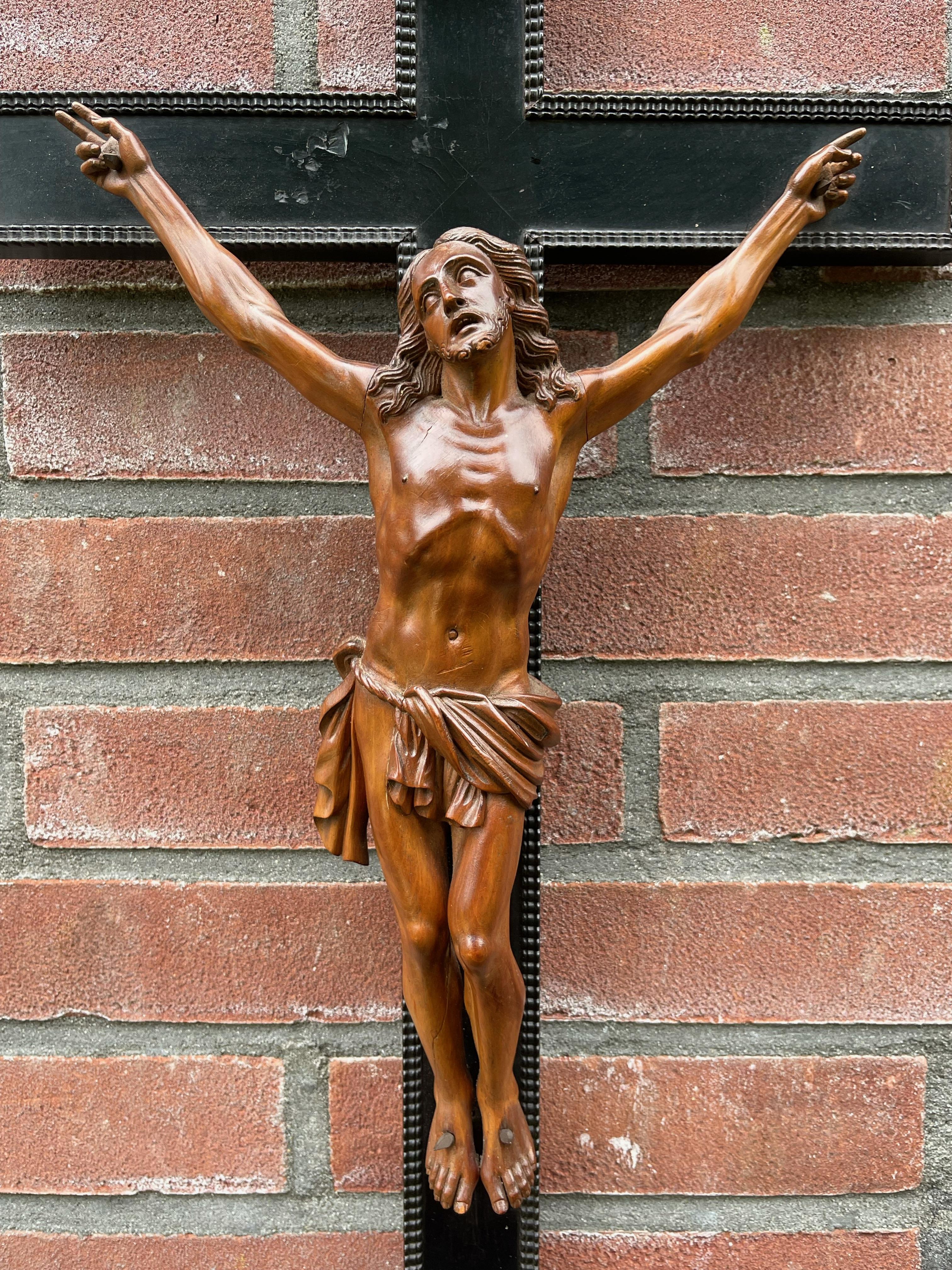 Antique crucifix with stunning hand carved details and an amazing patina.

This remarkable and sizeable sculpture of a suffering Christ on the cross is different to almost all others. The artist who hand-sculpted this impressive work of religious