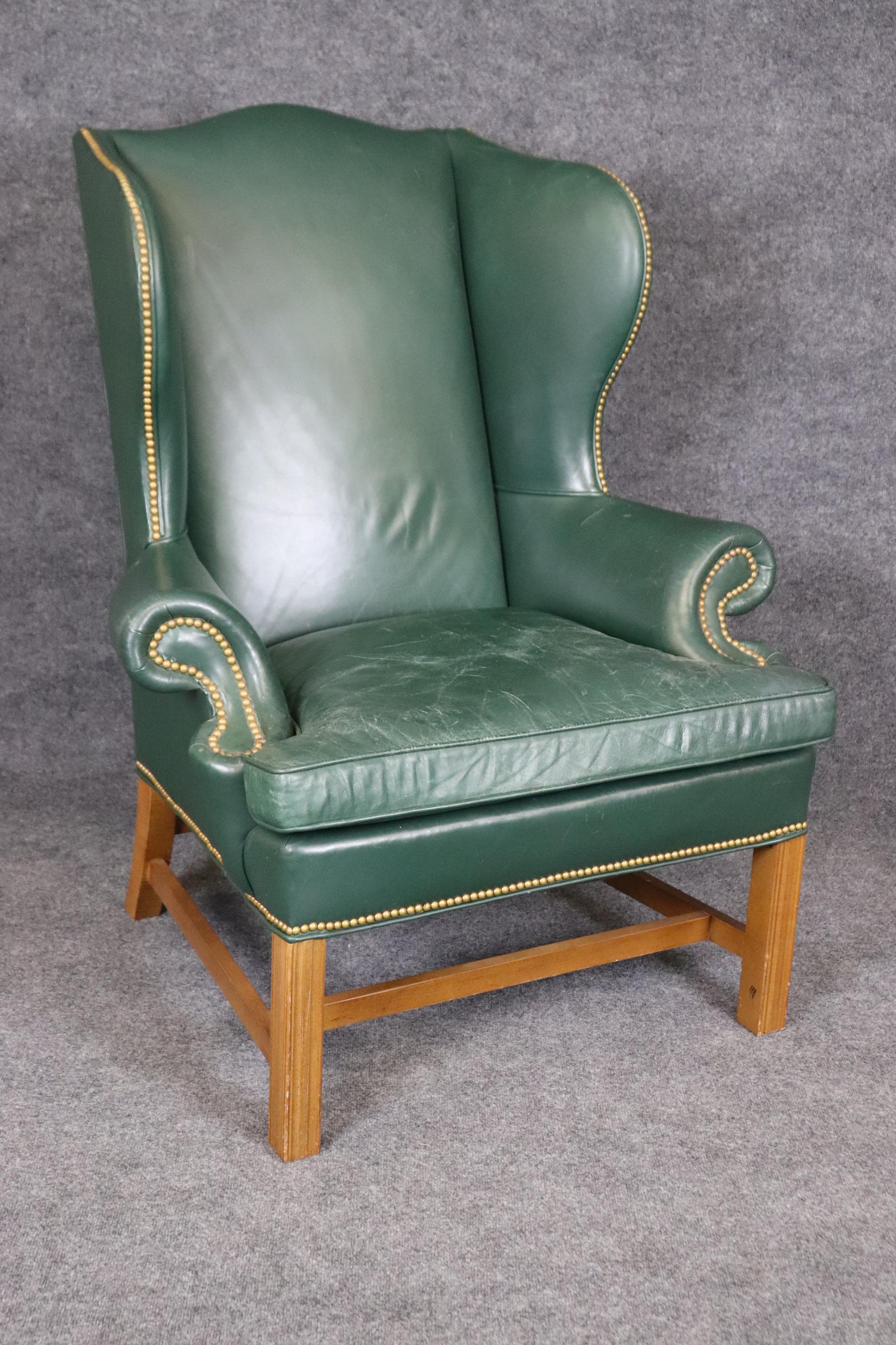 This is a great time-worn Century leather wingchair and ottoman. The chair features naturally distressed and worn leather upholstery and gorgeous Marlborough style legs. The leather is still in good condition but does show age cracks which can be
