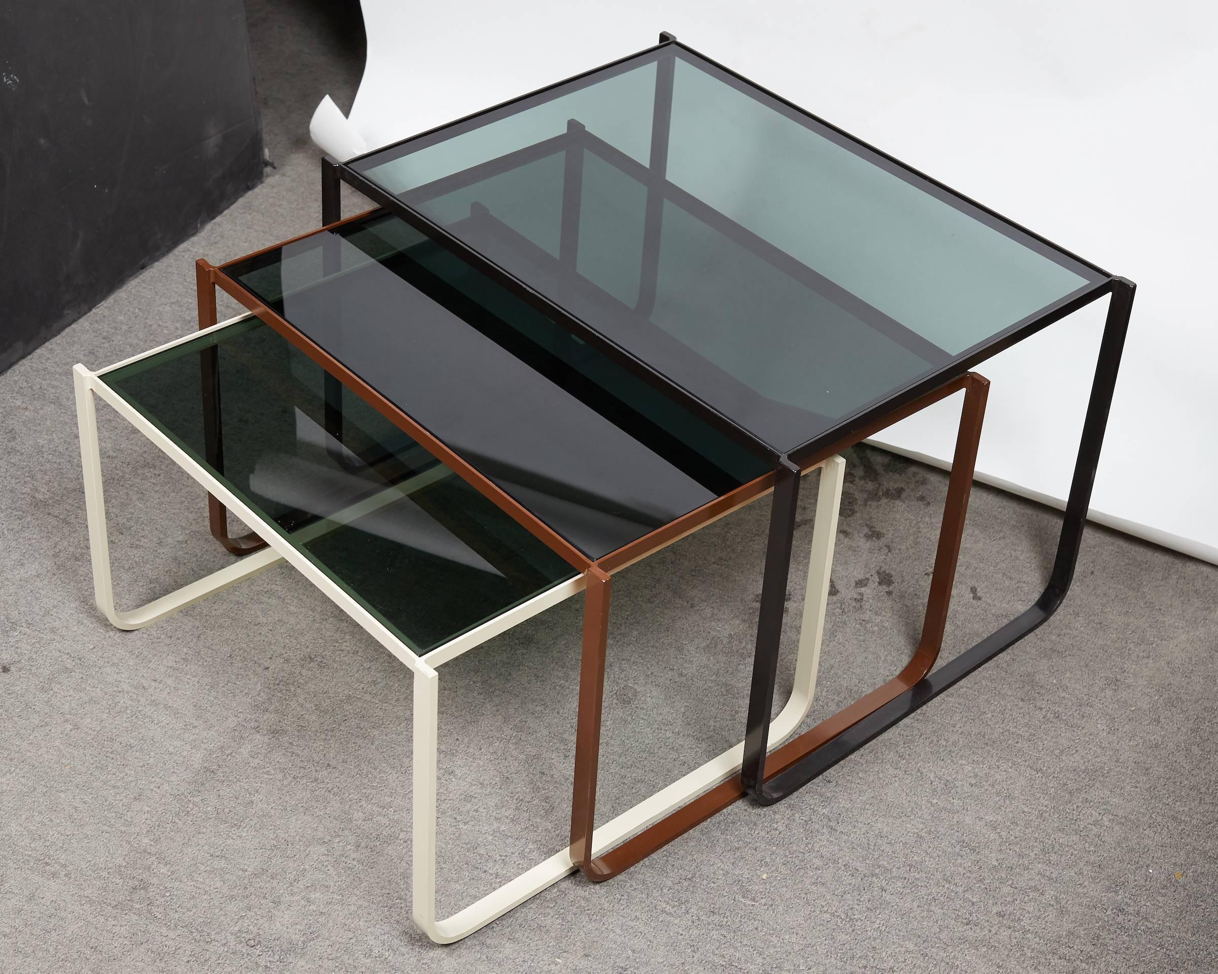 Great set of three enamel steel nesting tables fitted with smoked glass tops, consisted a white, chocolate brown and black color.