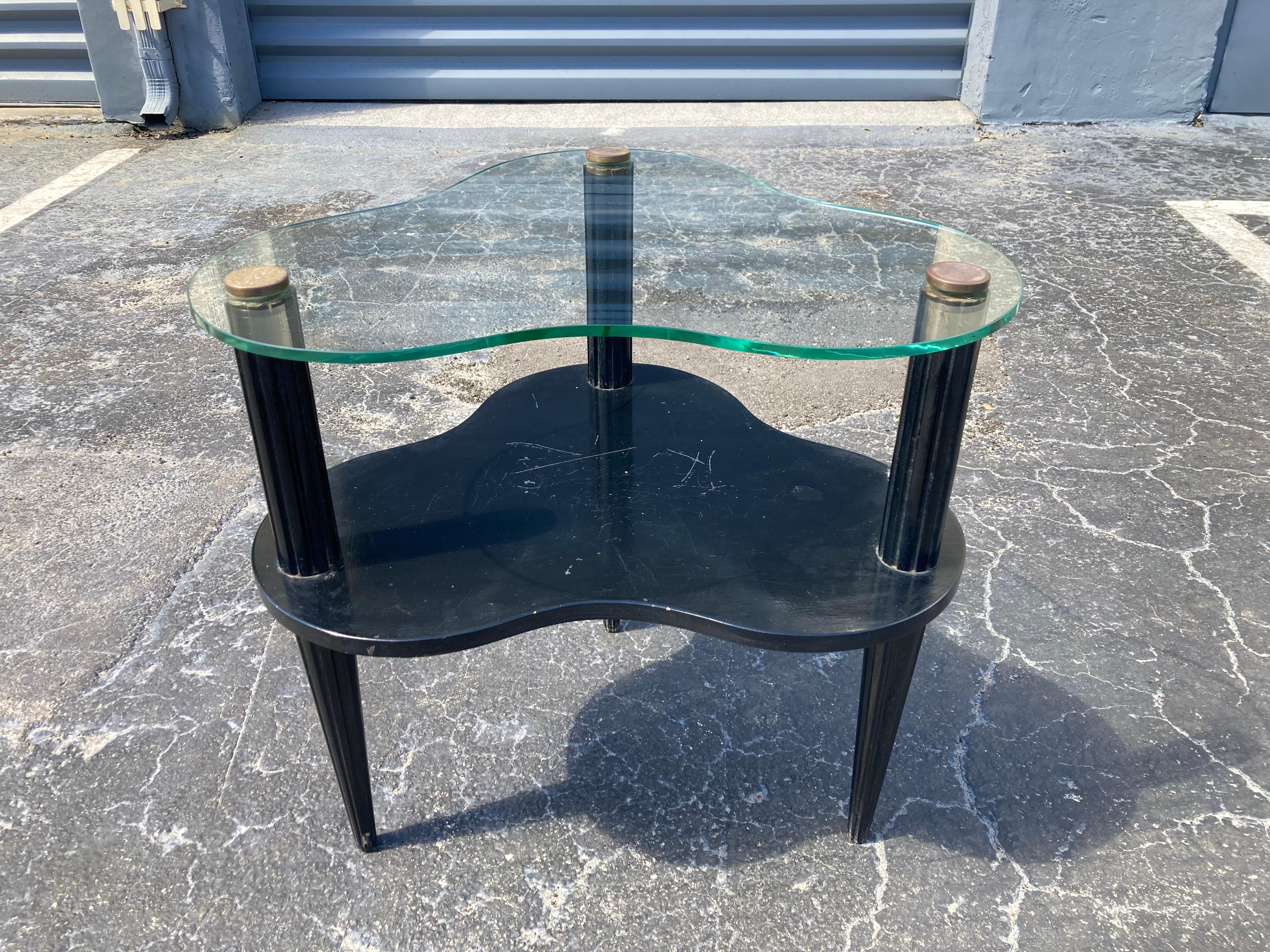 Superbe table d'appoint très probablement conçue par Gilbert Rhode, plateau en verre avec quincaillerie en laiton, bois fini noir. État d'origine, vitres sans dommages.