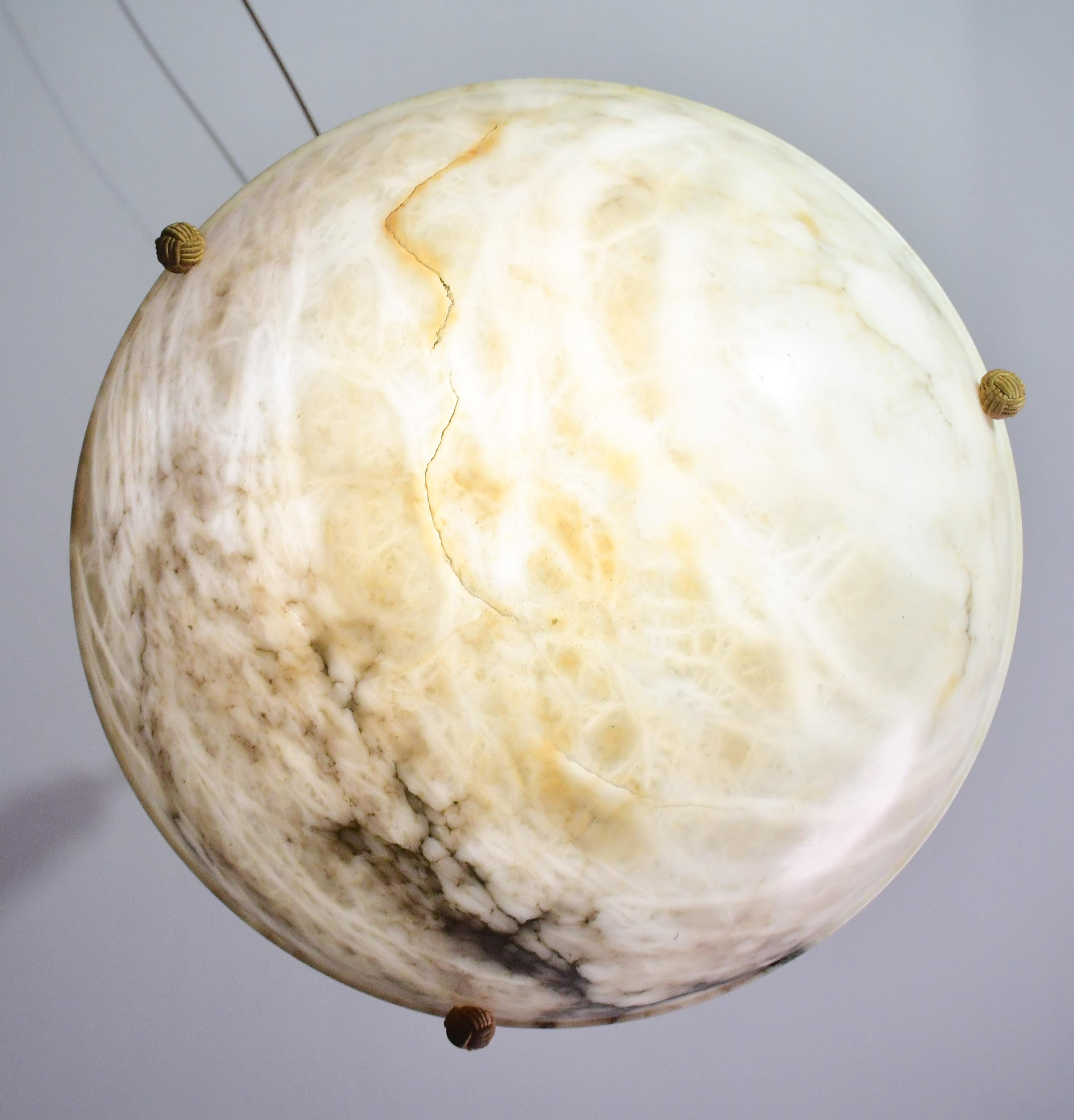 Antike Alabaster-Hängelampe im Art-déco-Stil aus den 1930er Jahren.
Ein einziges Stück Alabaster, wunderschön gearbeitet mit Schattierungen und Reflexionen anderer Farben, wenn es beleuchtet wird, aufgehängt an drei originalen Schnüren.
Das Licht,