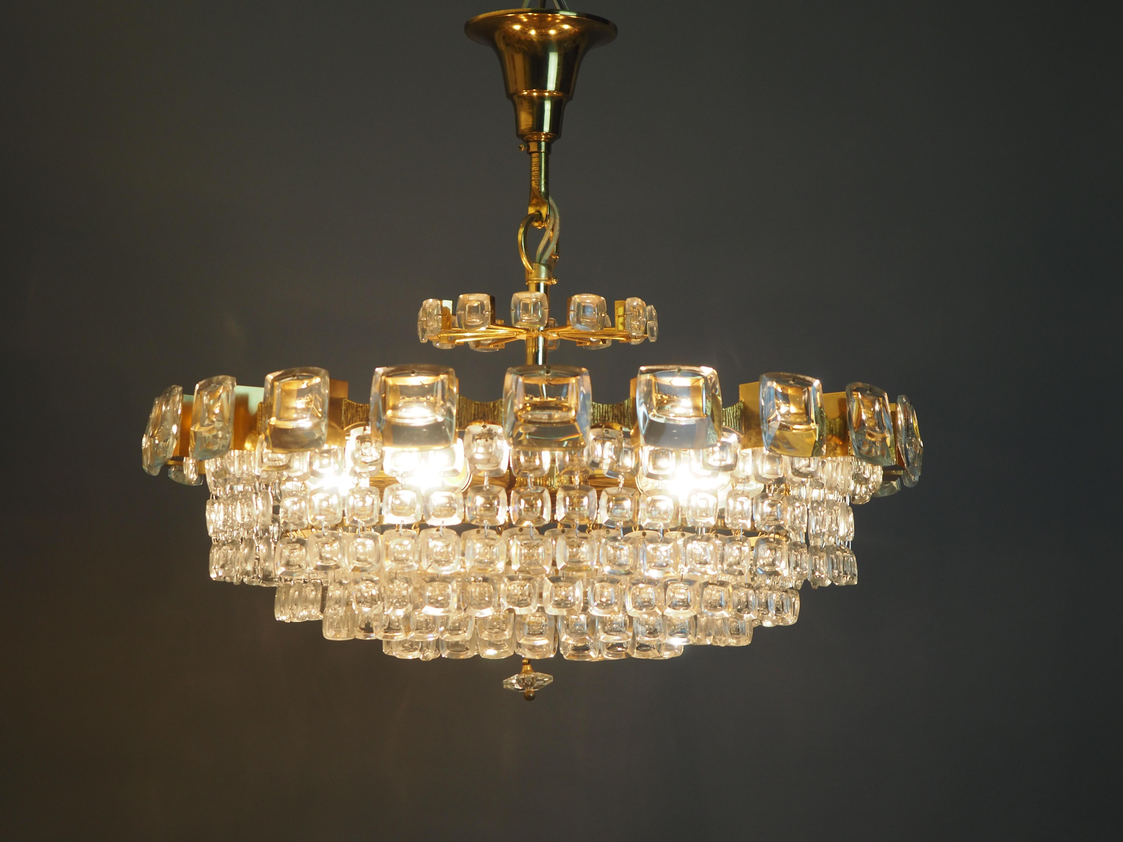 Wonderful midcentury, six-tiered gilt brass chandelier with square lens glasses.
A high quality light fixture in the Hollywood Regency style made by Palwa, Germany, circa 1970s.
The chandelier needs 5 x e14 (Edison) standard screw bulbs to