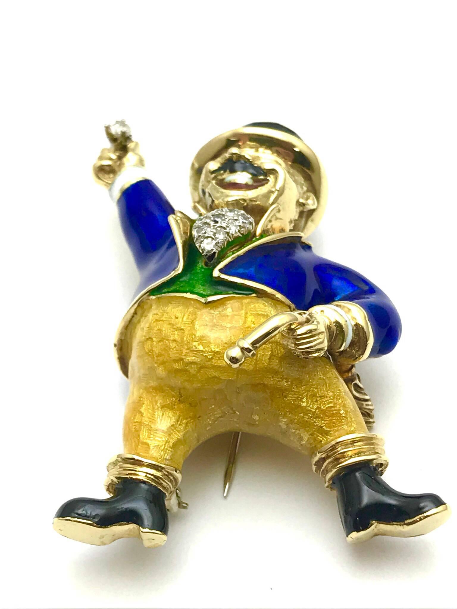 The Greatest Showman Ringmaster brooch, made from 18 karat yellow gold, with diamond, and multi color enamel.  The ringmaster is in traditional attire of a black top hat, a bright gold trimmed blue tailcoat, tufted white scarf, made up of round