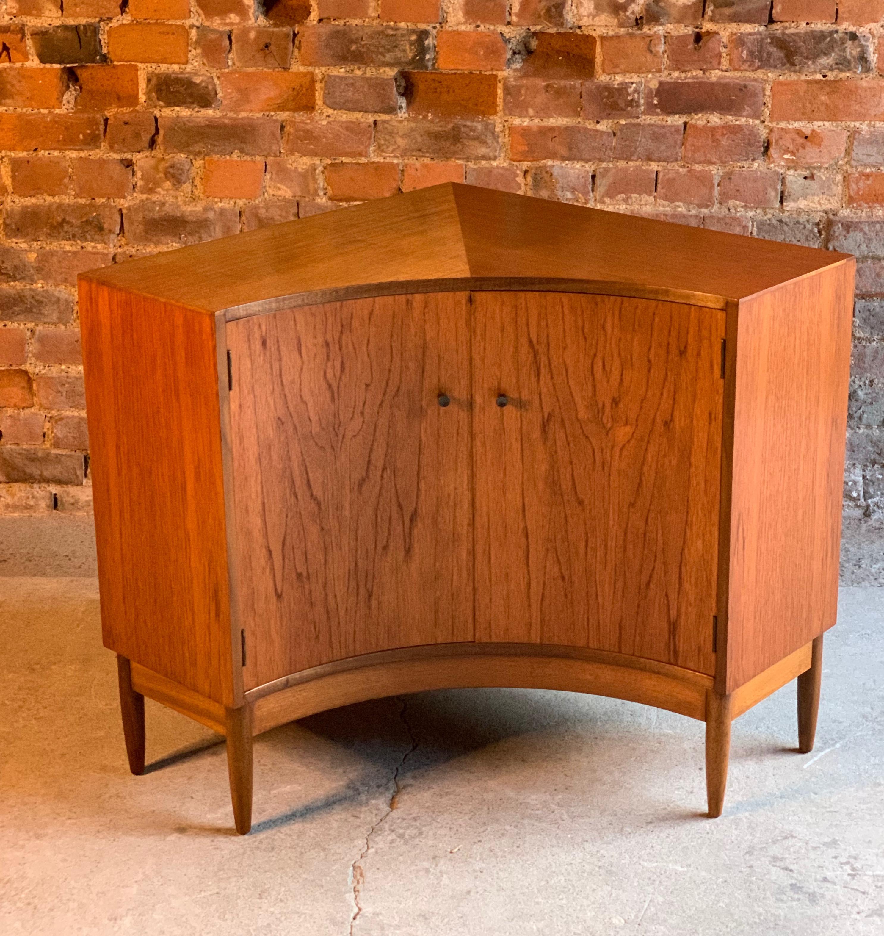 Magnificent midcentury Greaves & Thomas African teak corner cupboard or sideboard, the convex design saving wall space by utilizing corner space, thus giving maximum room to limited spaces, the triangular top over two cupboard doors with internal
