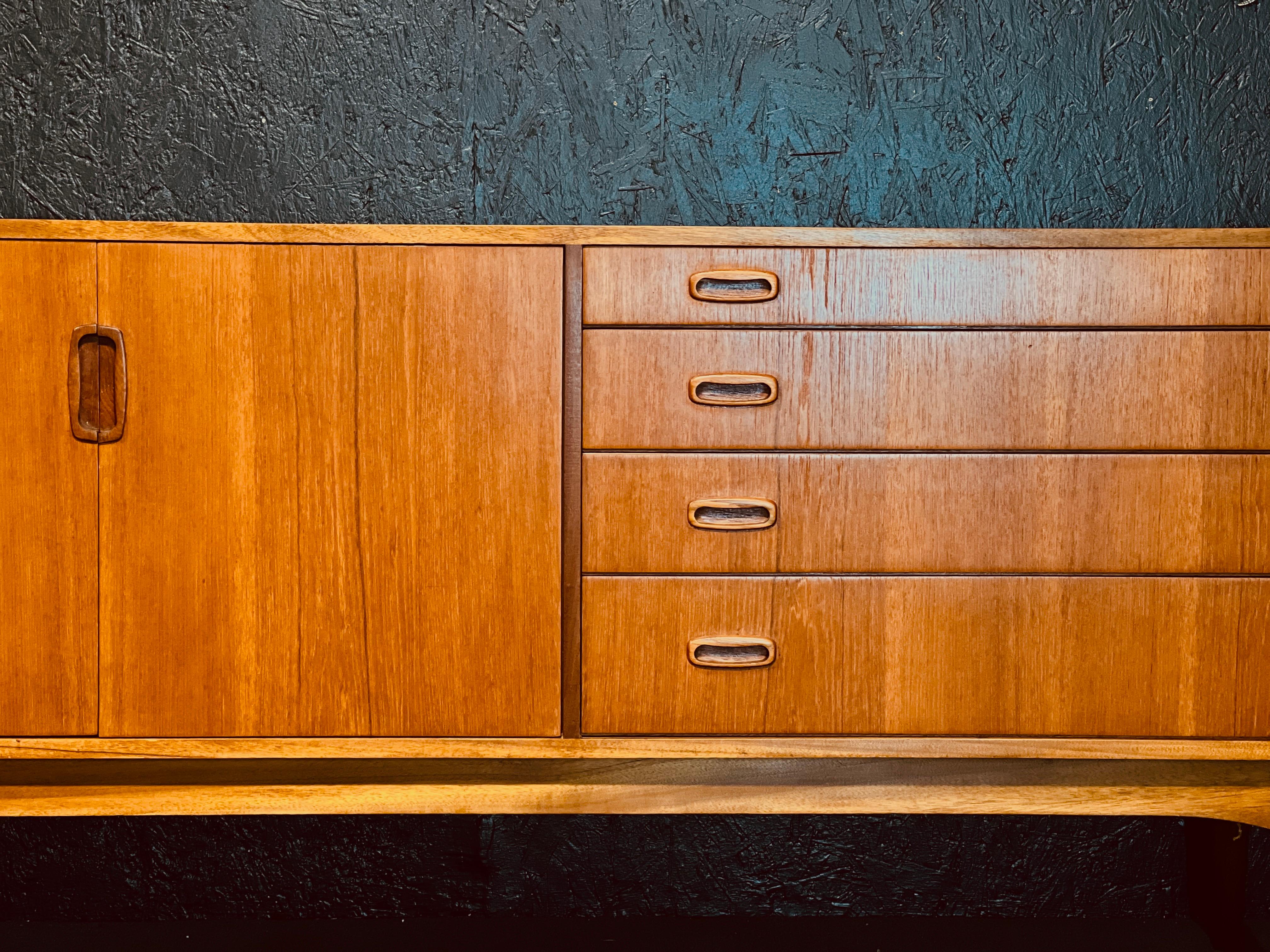 Mid-Century sideboard from the English brand Greaves & Thomas built-in teak in the 60s.

Greaves & Thomas was a London-based furniture maker based in Clapton, in the London Borough of Hackney, from 1911 till 1965.

The sideboard features a