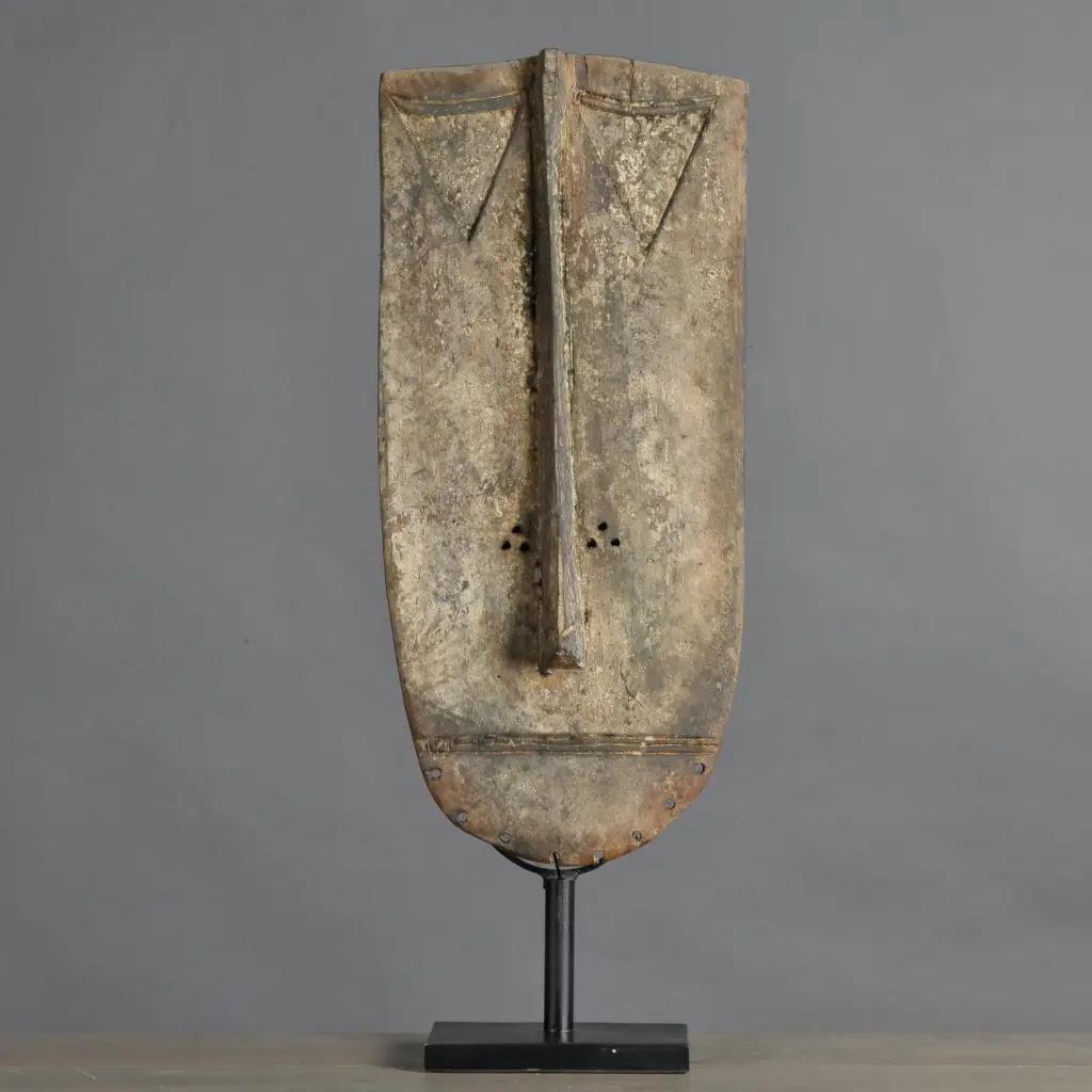 This Grébo tribal mask carved from patinated wood is a remarkable piece of ethnic art, symbolizing the culture of the Grébo people from Ivory Coast. Featuring a long, straight nose placed between six eyes, it expresses the power and depth of African