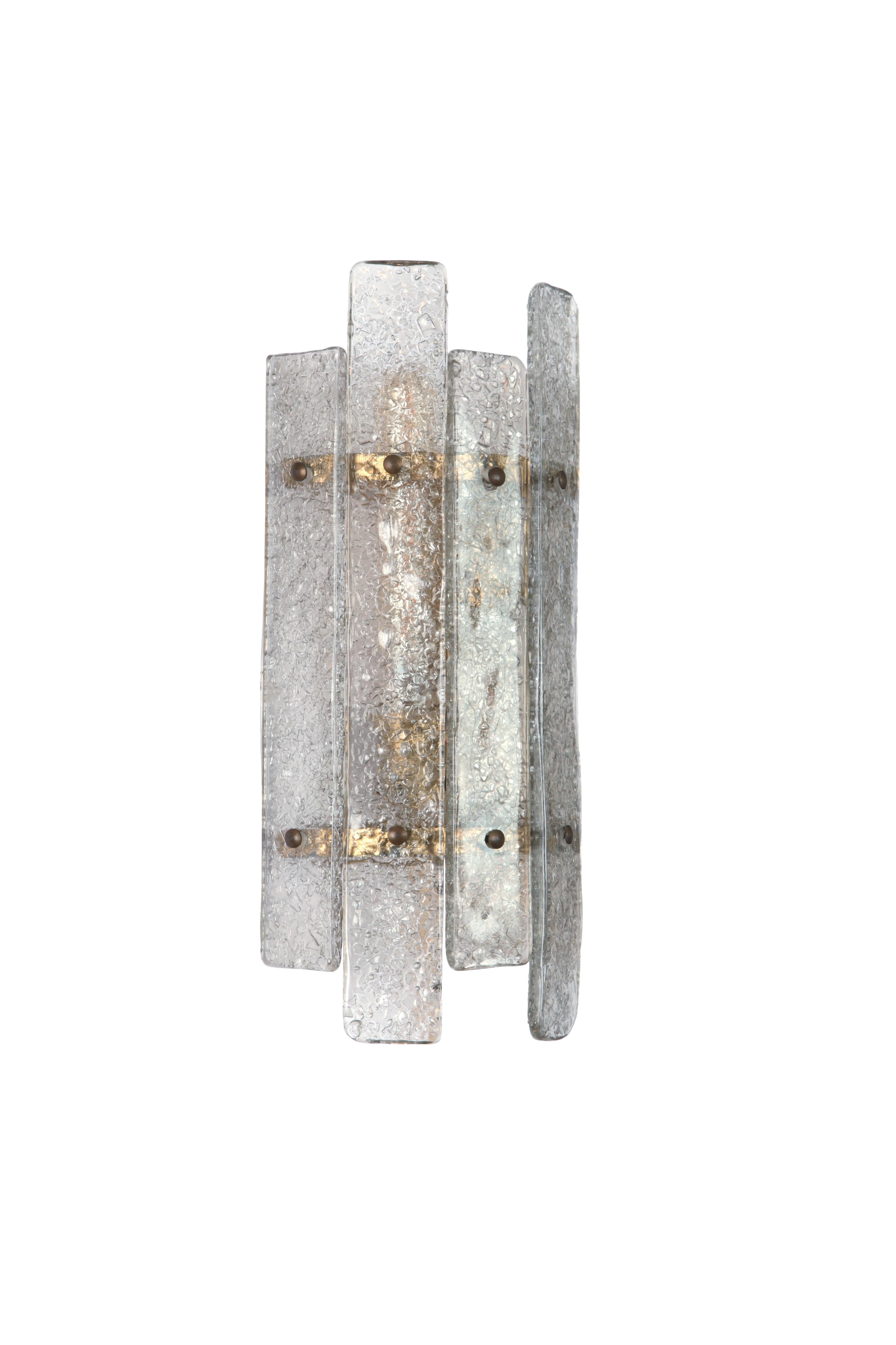 Wall sconces from Italy with textured Murano glass panels. Tiny pieces of glass were fused to the glass panels which refract the light when it shines through. The glass has a light smoke colour to it.

Brass frame with aged brass screws.

Wired for