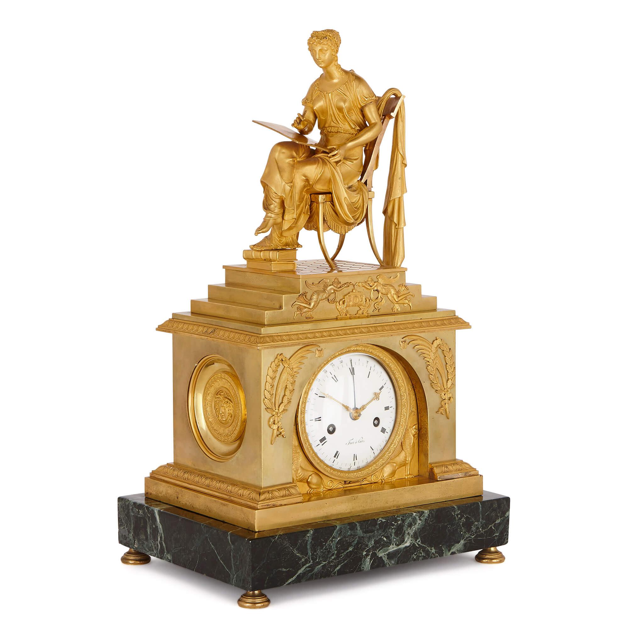 Crafted in the Empire style, this mantel clock features a rectangular green marble base, topped by a gilt bronze (ormolu) body, containing the clock dial. Surmounting this body is a stepped platform, decorated with Napoleonic symbols, upon which a