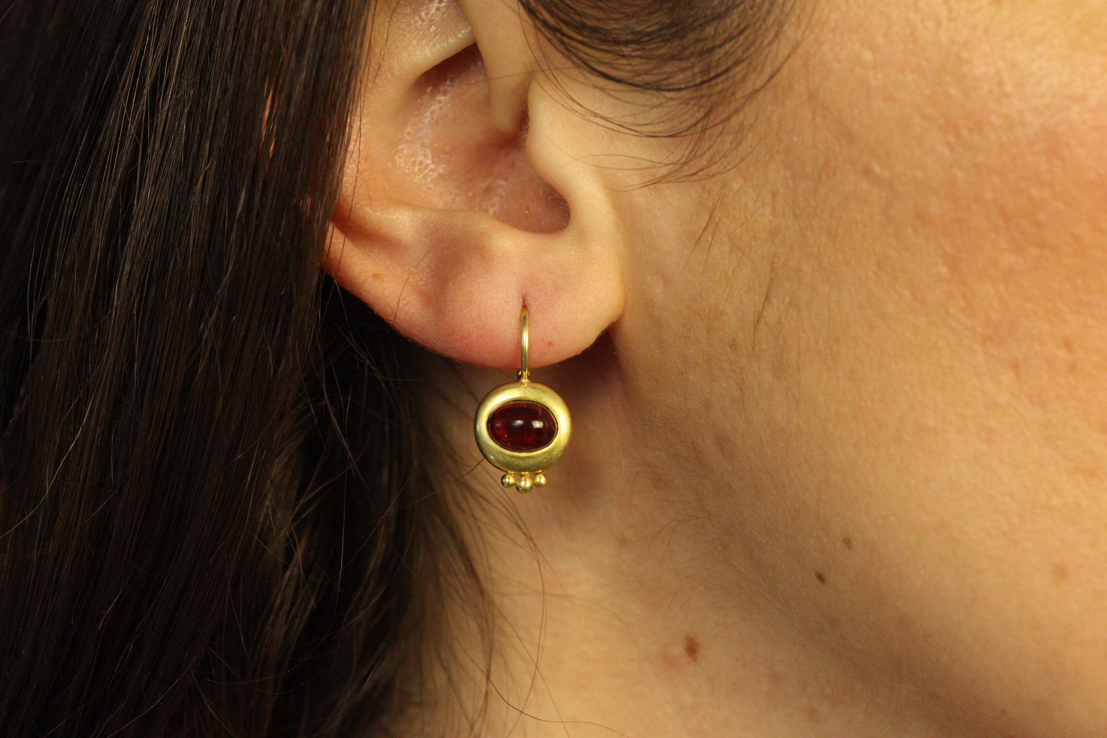 Questi orecchini Greco in oro californiano 20 carati presentano gemme di tormalina rubellite. Il rosa brillante delle pietre di rubellite tagliate a cabochon contrasta meravigliosamente con le calde tonalità verde-oro della montatura. Elegati con