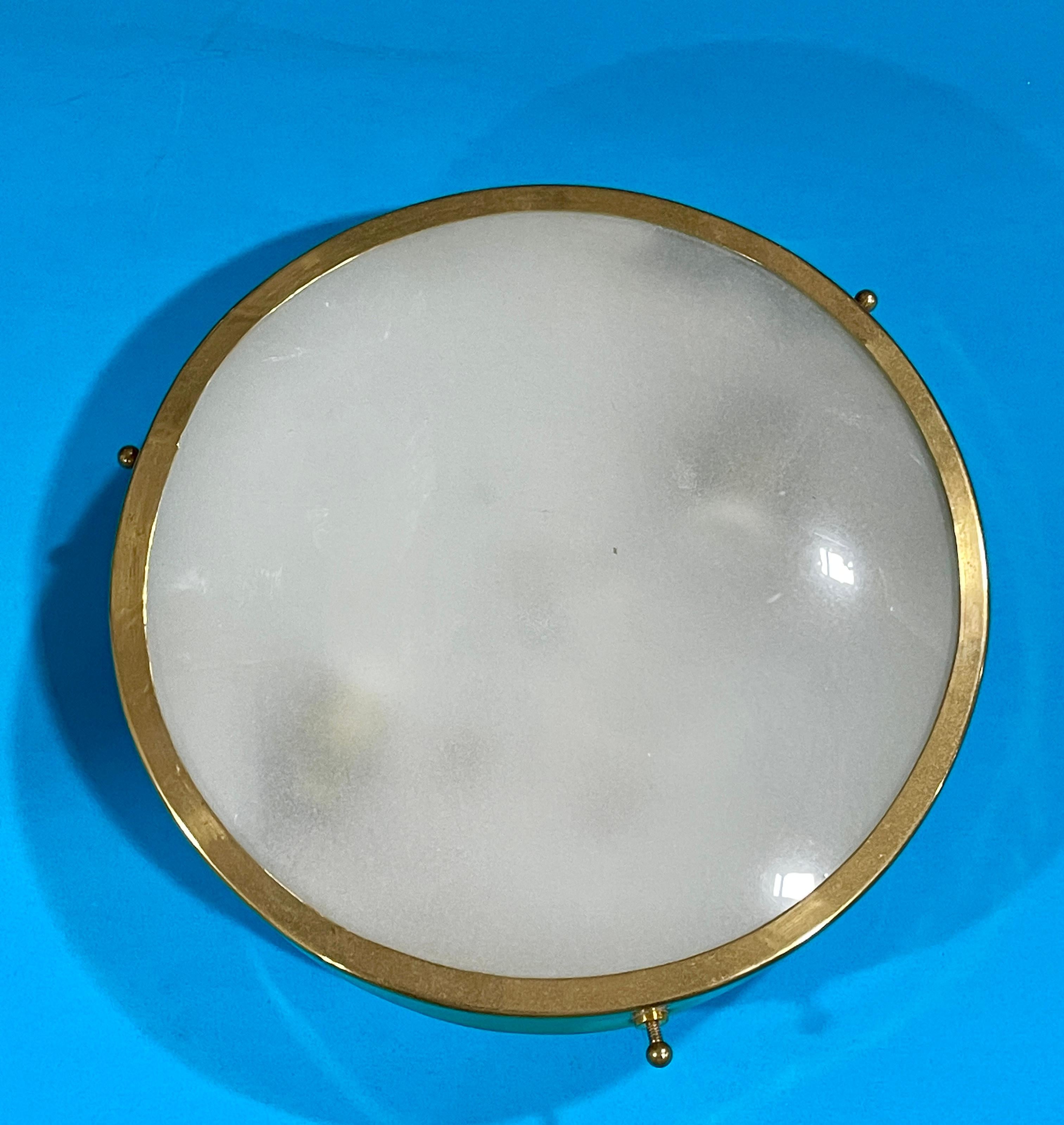 Greco Illuminazion round brass ringed mini flush mount or wall light with convex glass sandblasted on the inside. 8” diameter 2” high fitted with two candelabra sockets up to 60 watts each.
