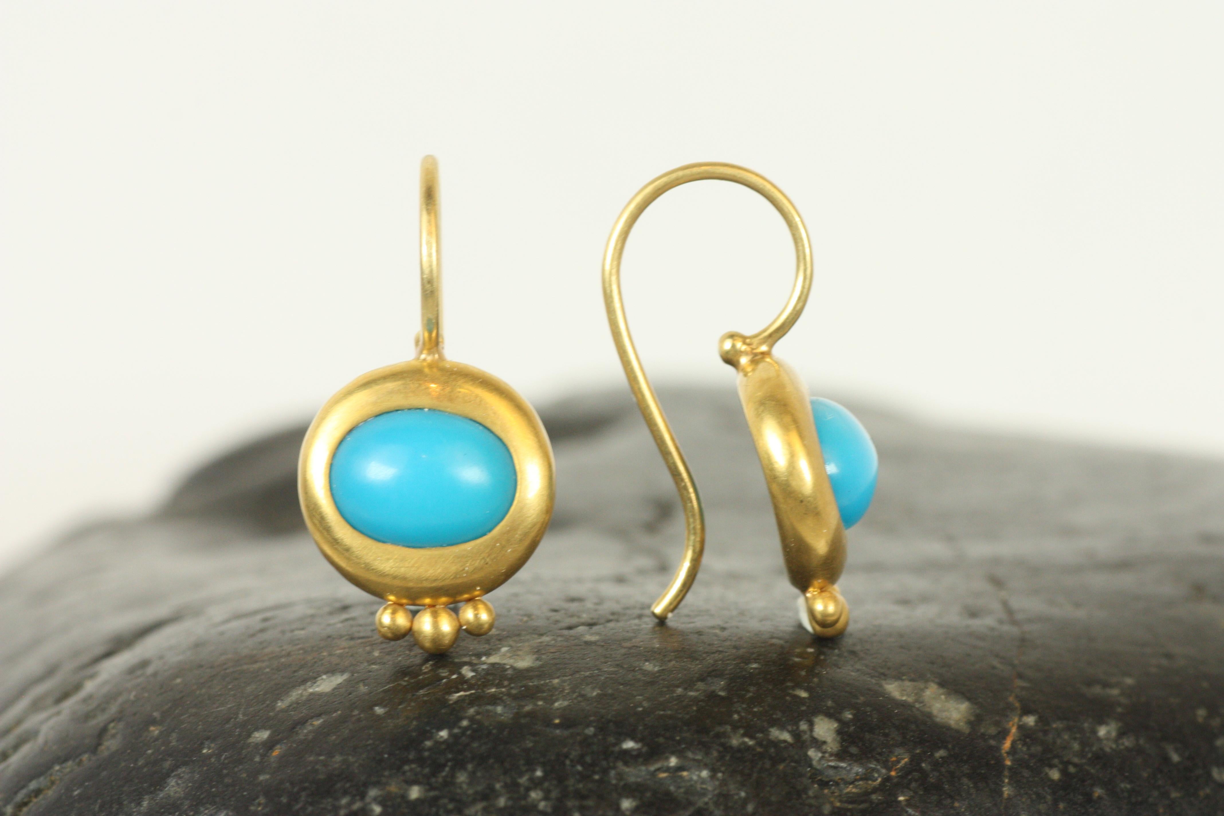 Le vibranti gemme di turchese di questi orecchini Greco in oro giallo 22 carati sono incastonate a castone per un look sorprendente. La tonalità blu brillante del turchese si integra con i caldi bagliori dell'oro, mentre i tre piccoli punti dorati