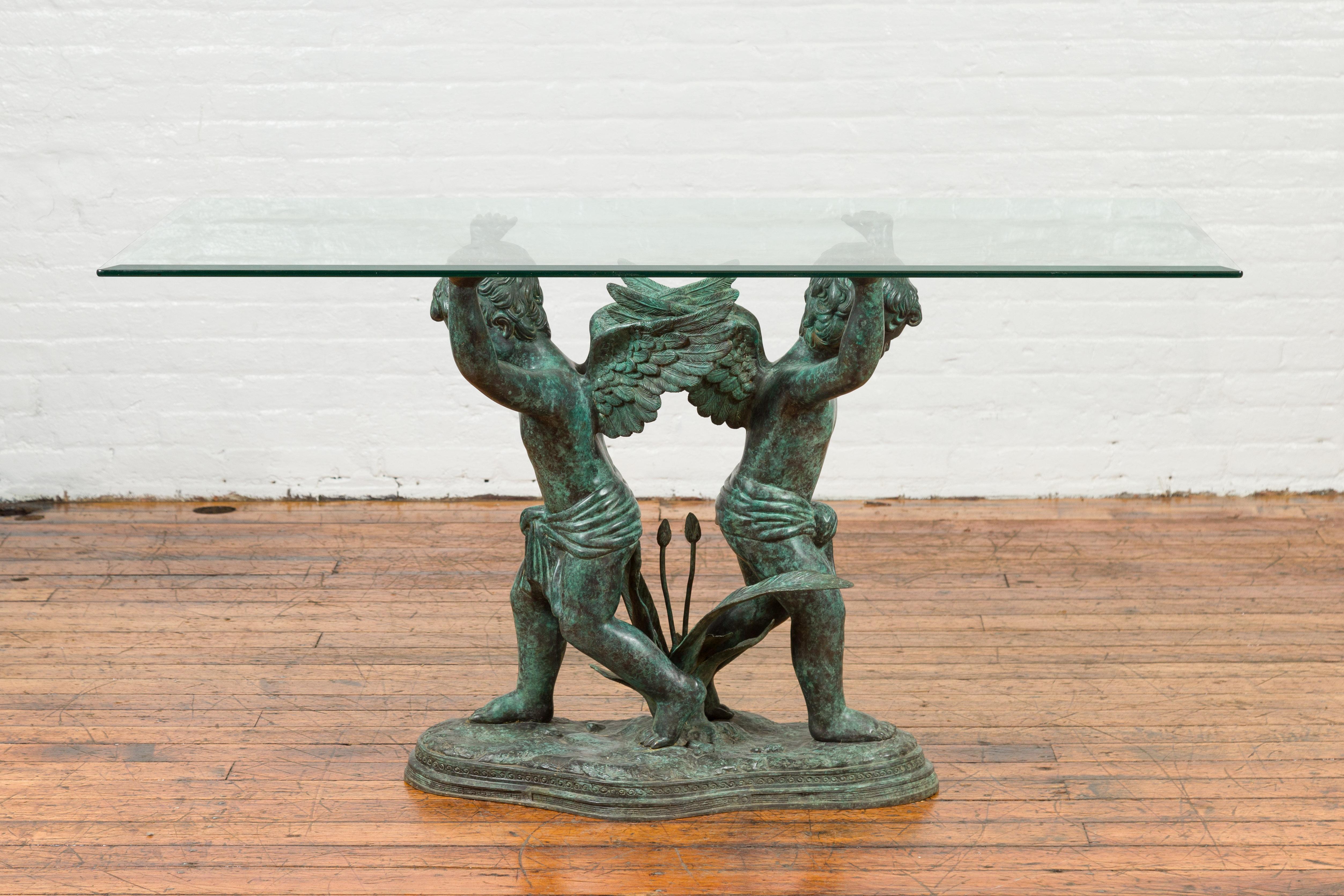 A Greco-Roman style contemporary bronze double cherub dining table base with Verde patina. The top is not included. Created with the traditional technique of the lost-wax (à la cire perdue) that allows great precision in the details, this