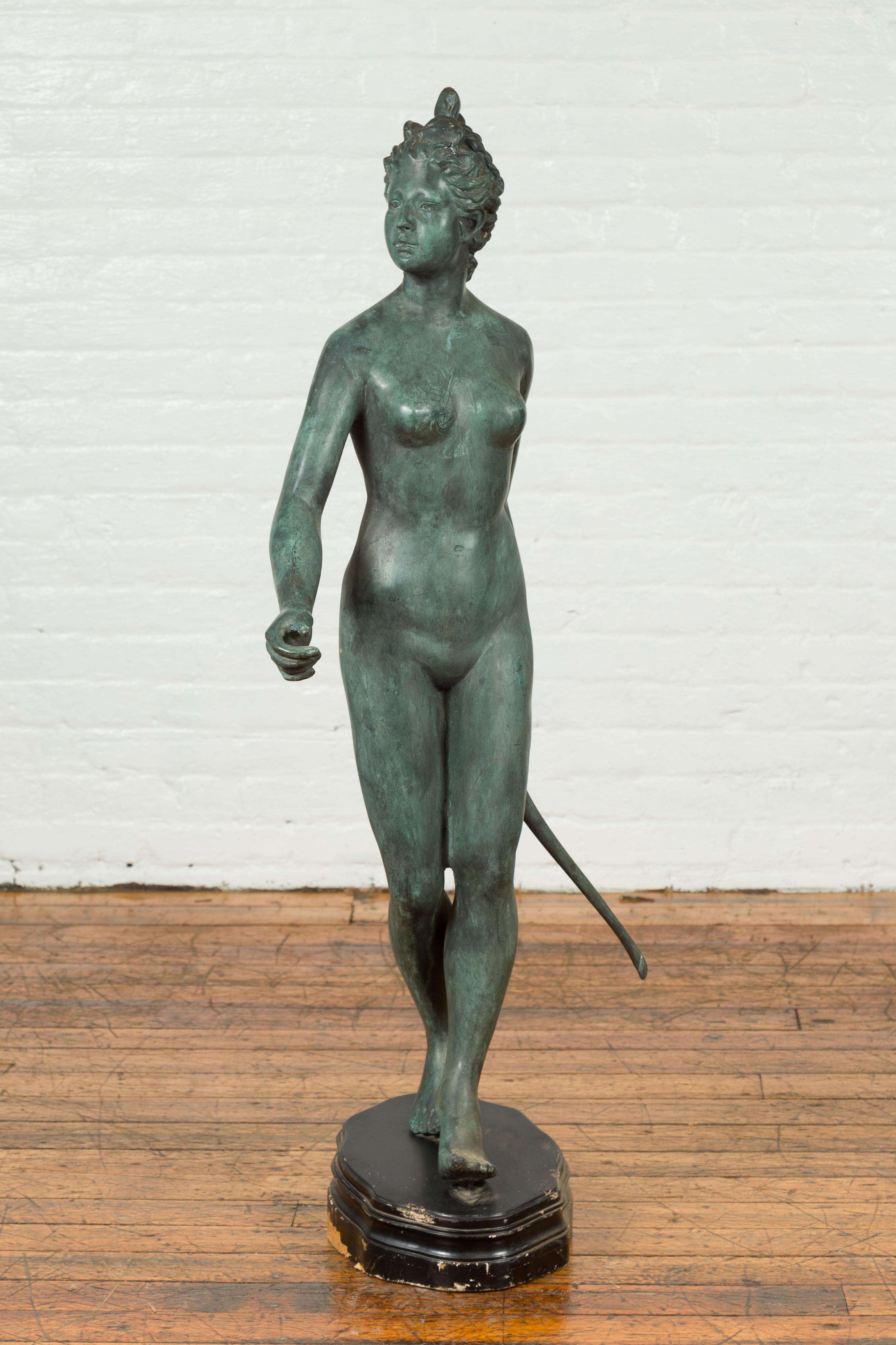 A Greco-Roman style vintage verde bronze statue of Diana The Huntress from the mid 20th century, with the goddess holding her bow. Created with the traditional technique of the lost-wax (à la cire perdue) that allows a great precision and finesse of