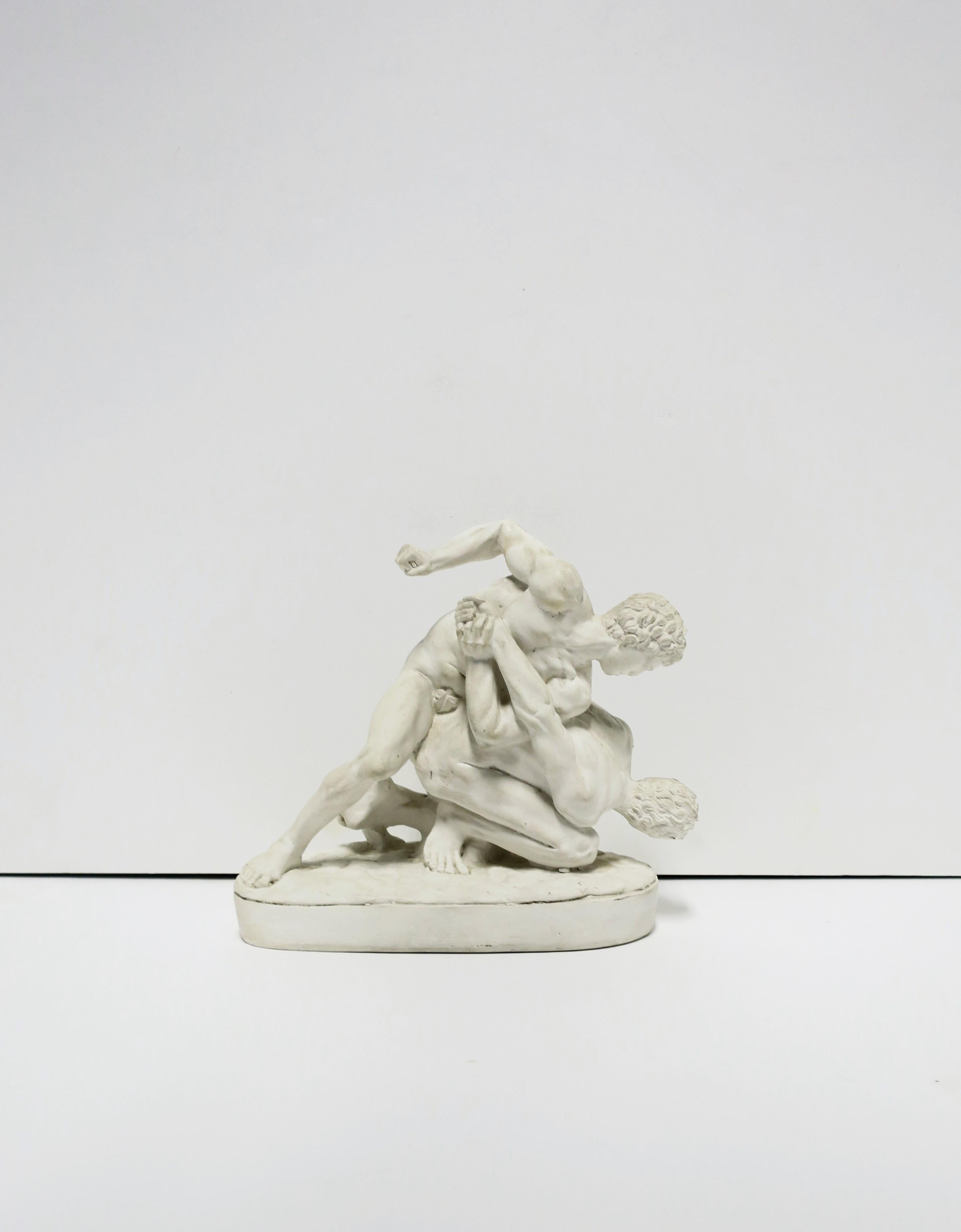 A white plaster reproduction Greco Roman sculpture of two men wrestling, circa mid-20th century. Sculpture is based on the original from the 3rd century. A great decorative object for any office, library, bookshelf, etc. Dimensions: 4