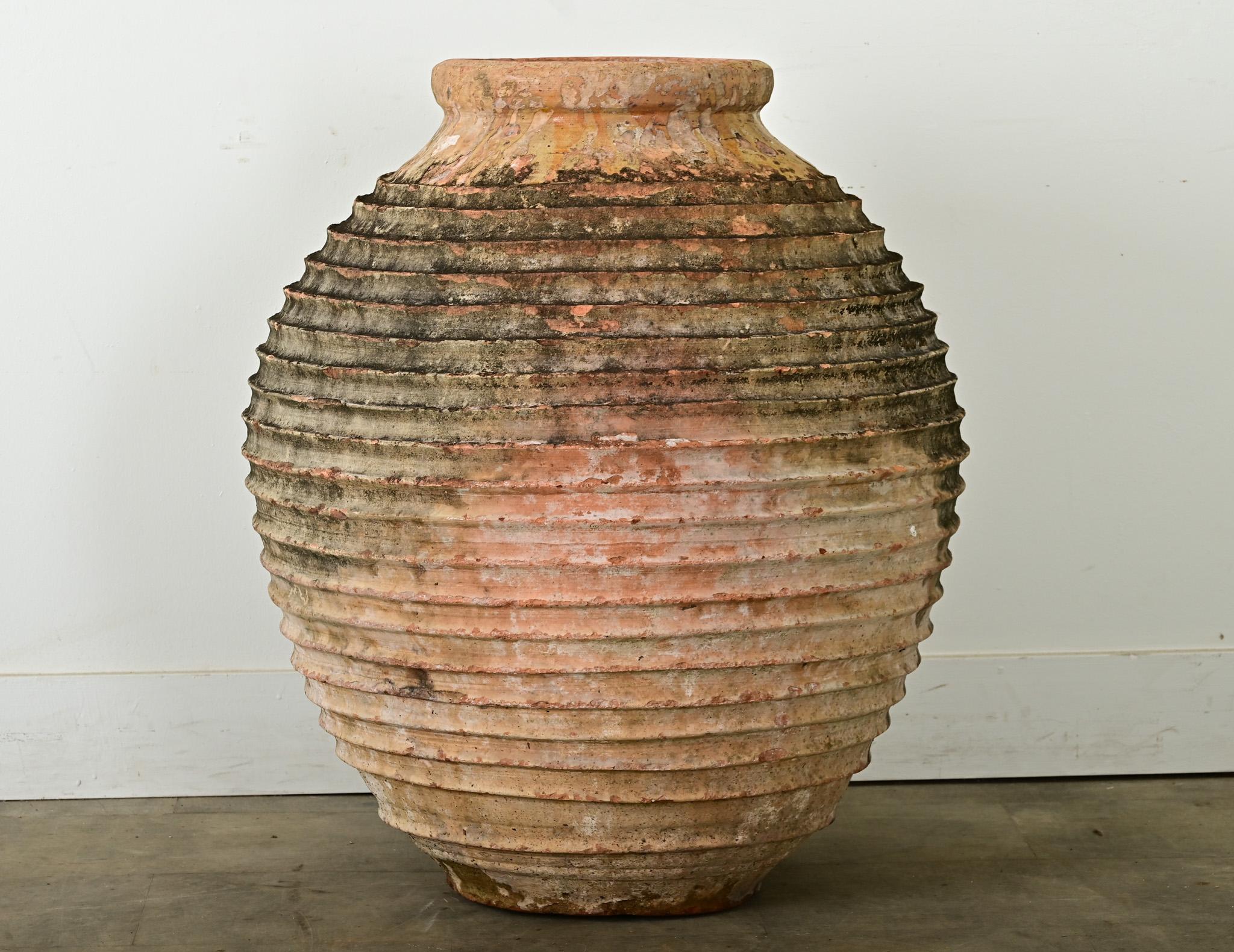 Impressive Greek olive jar from the 18th century, the terracotta darkened by natural oils and three centuries of use. This antique vessel, once used to hold olives and their oil, features a rounded lip around the narrow opening, with a bulbous form