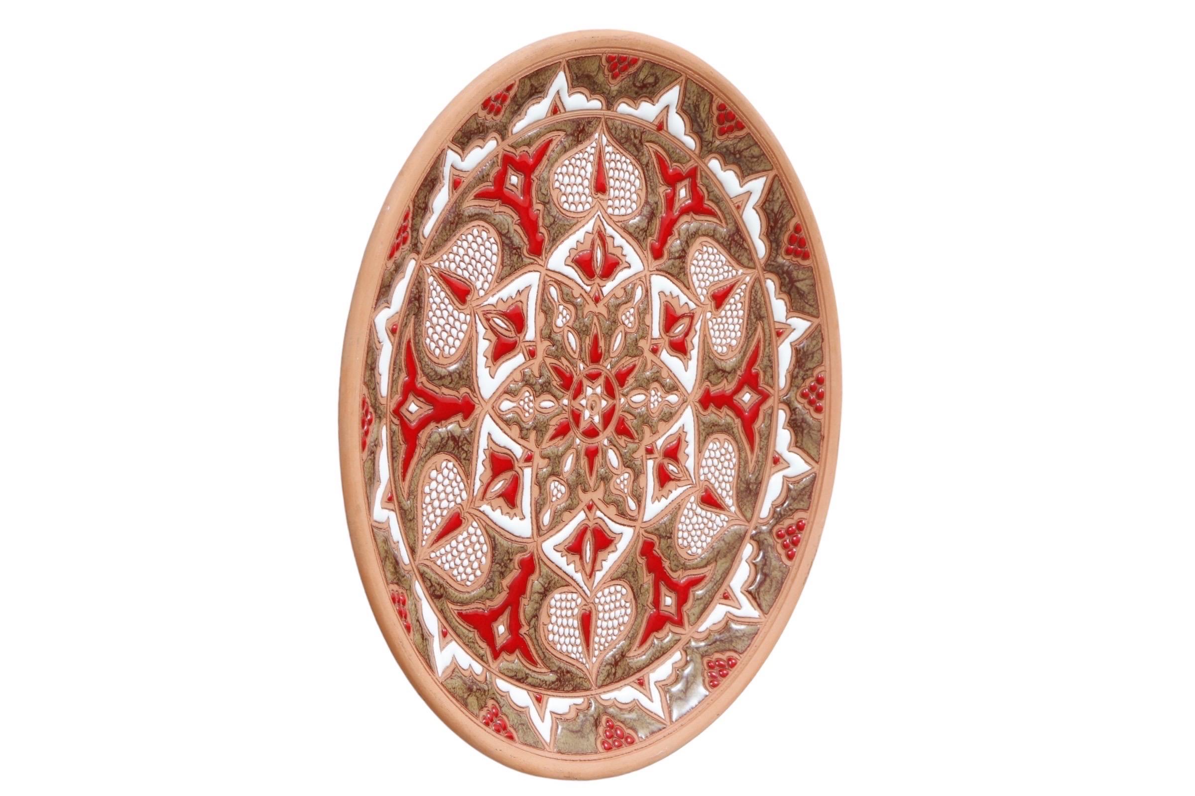 Assiette artisanale fabriquée à la main par Bonis Pottery of Rhodes Greece, vers 1970. Décorée d'un motif original de cœurs et de feuilles émaillés en rouge et vert olive avec du blanc, sur un fond d'argile rouge. Signé au dos 