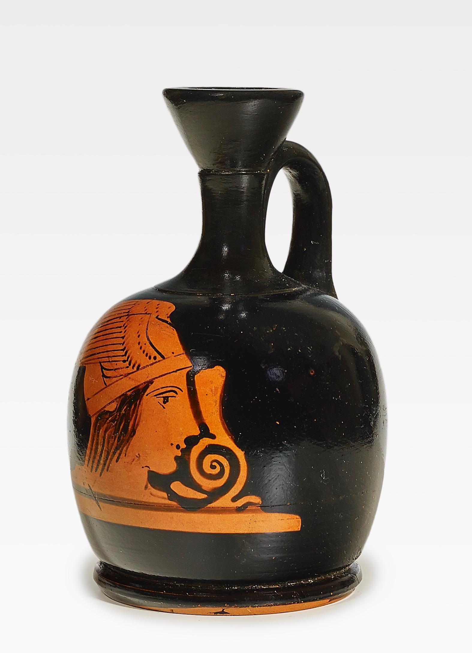 Attic red figure squat-lekythos depicting the head of Hermes. Athens, mid-5th century BC. Neck, orifice and handle professionally restored. This is very common for Greek vases and has no influence on its value. Almost all vases in museums are