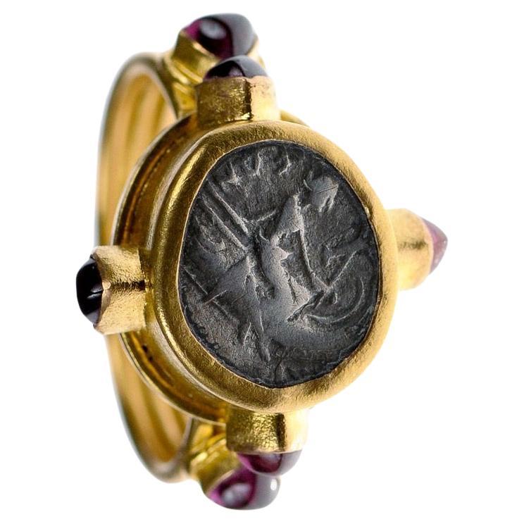 An Authentic Ancient Greek Coin Euboia, Histiaia. Circa 196 - 146 BC. A Silver Tetrobol Head of nymph Histiaia, Nymph seated upon a prow. Set in a 22K Gold Ring accompanied by Six Ruby Gem Stone Accents. This ring is a size 7.