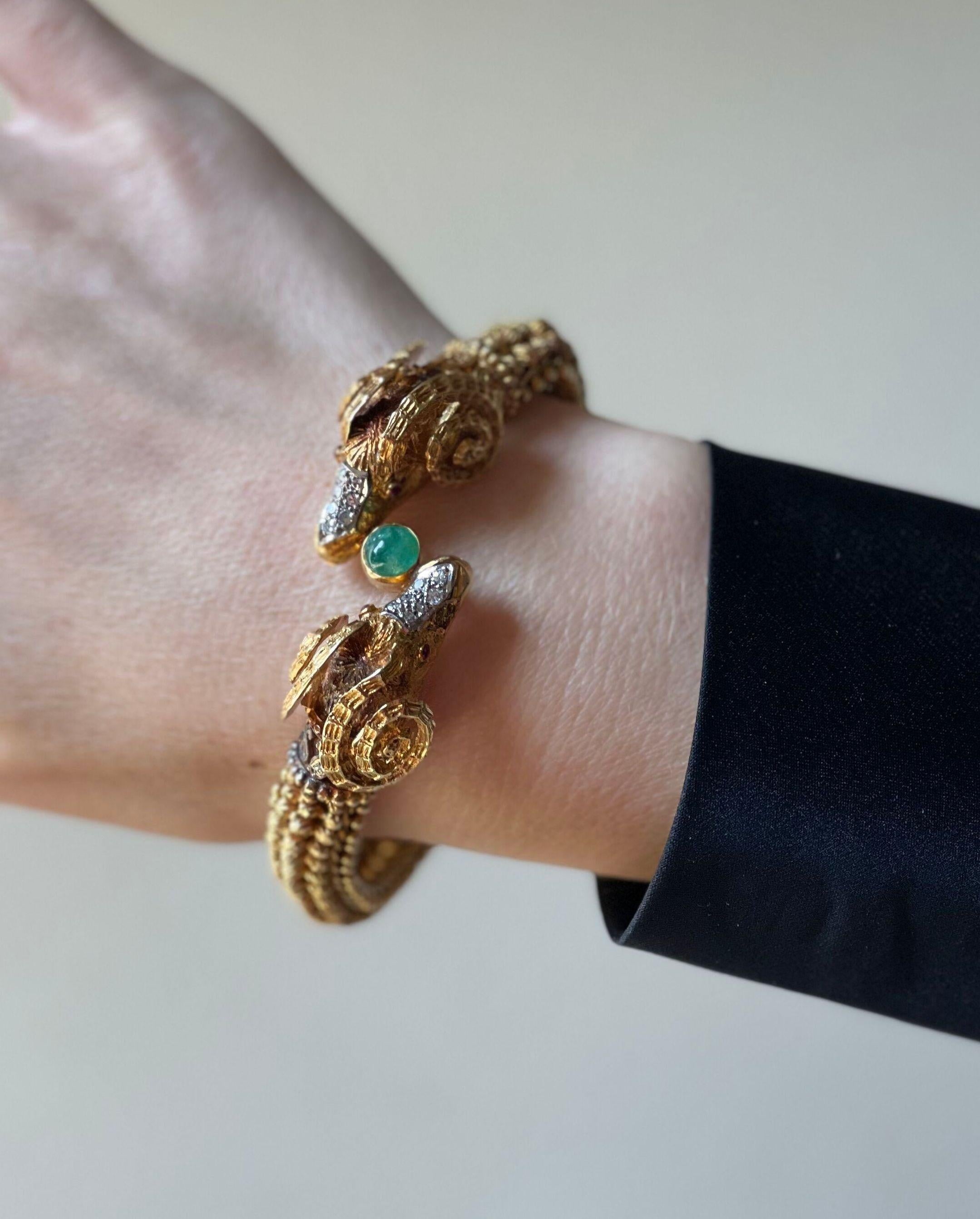 Impressionnant bracelet en or 18k de fabrication grecque, présentant deux têtes de bélier, ornées d'un cabochon d'émeraude, d'yeux de rubis et d'environ 0,30ctw de diamants H/Si. Le bracelet convient à un poignet de taille moyenne  - environ
