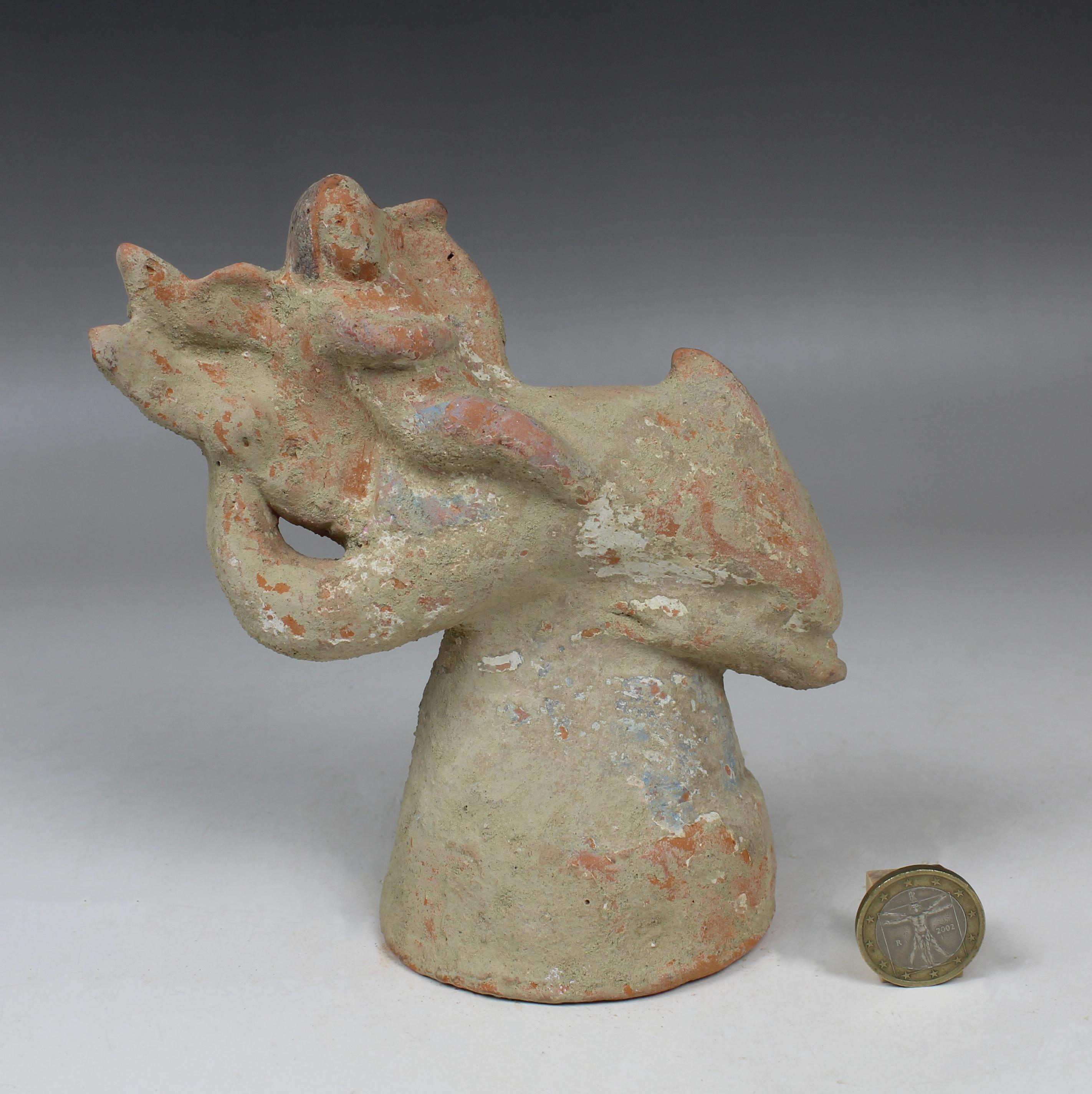 Pottery Greek figurine of a little Eros riding on a dolphin, holding a lyre For Sale
