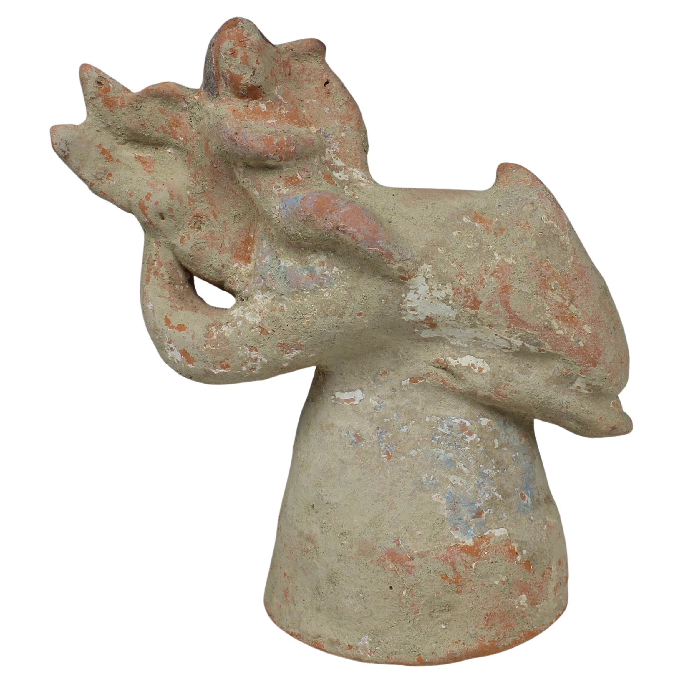 Greek figurine of a little Eros riding on a dolphin, holding a lyre For Sale