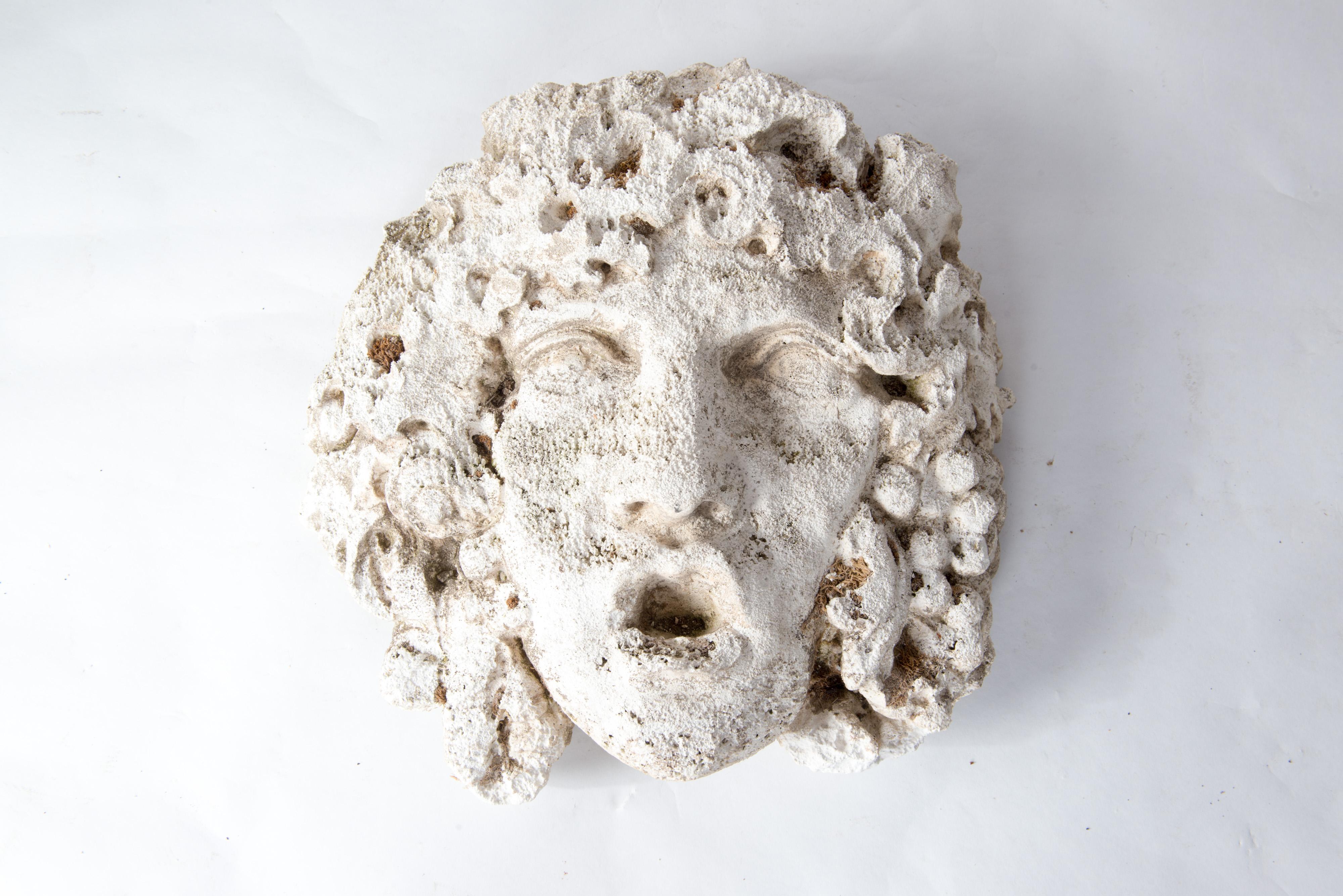 Wonderfully weathered Medusa mask in cast stone as a garden ornament.