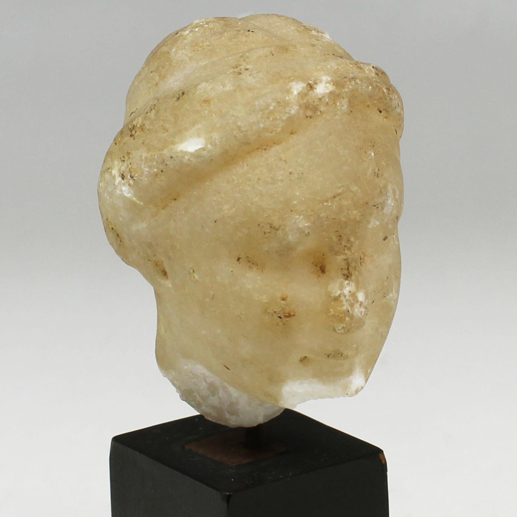 ITEM: Head
MATERIAL: Marble
CULTURE: Greek, Hellenistic period
PERIOD: 3rd – 1st Century B.C
DIMENSIONS: 55 mm x 38 mm x 44 mm
CONDITION: Good condition. Includes stand
PROVENANCE: Ex Swiss private collection, acquired since at least 1982

Comes