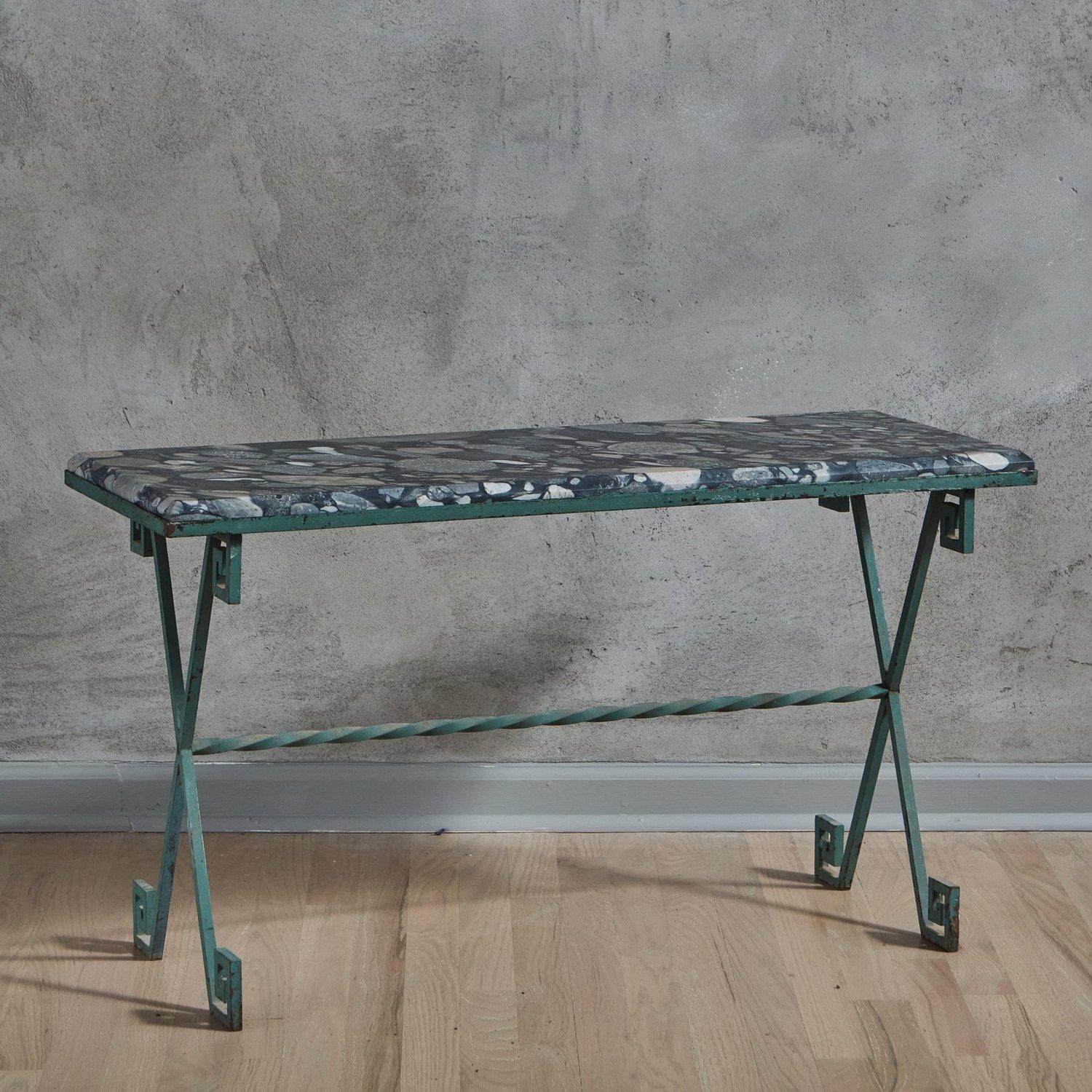 A 1960s French coffee table featuring a green metal base with greek key motifs and a center stretcher. This table has a gorgeous rectangular Marinace Verde granite top with a bevel edge featuring a range of green and blue hues. Unmarked. Sourced in