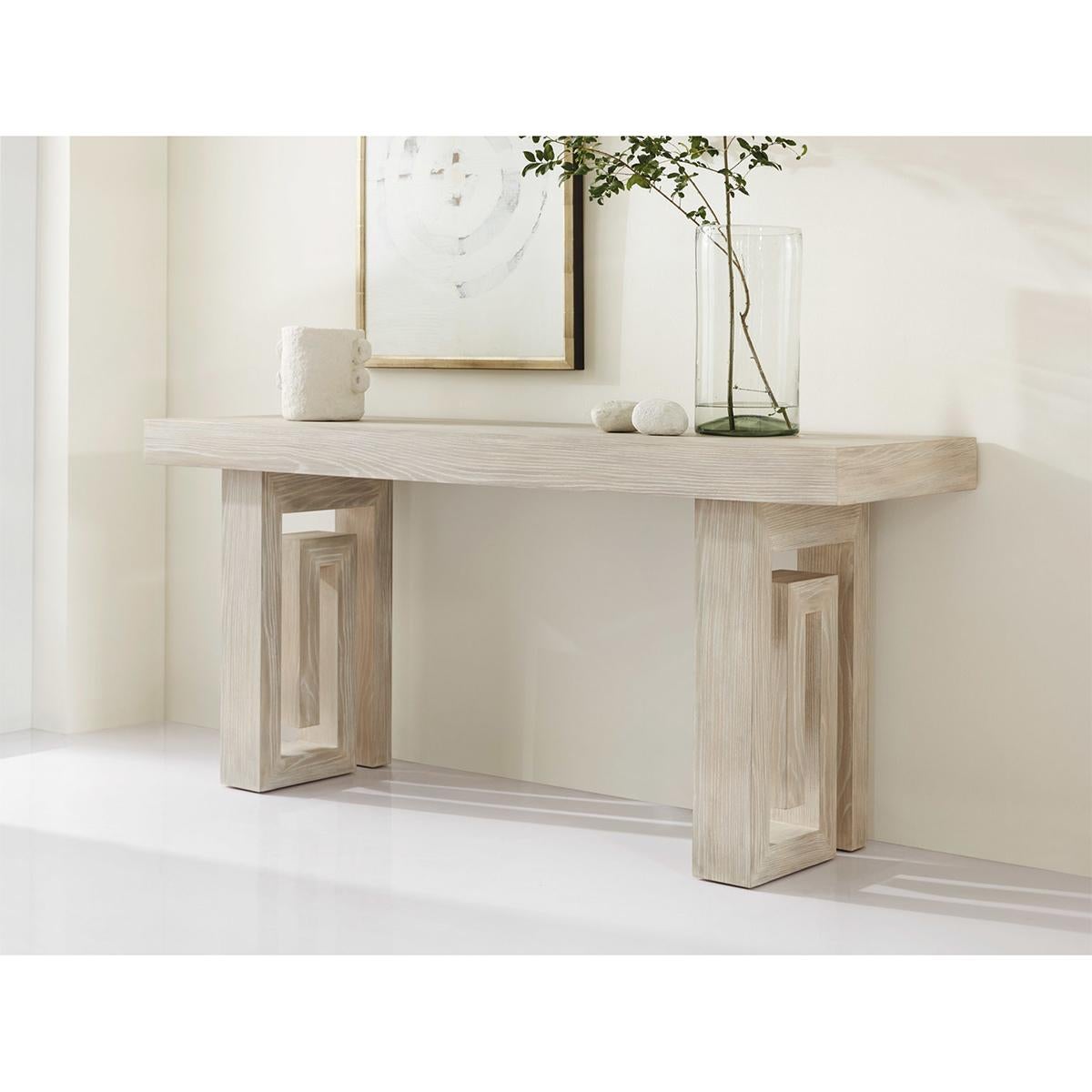 Large console with whitewash ash veneer has a bold block form top raised on two Greek key shaped pedestal legs.

Dimensions: 70